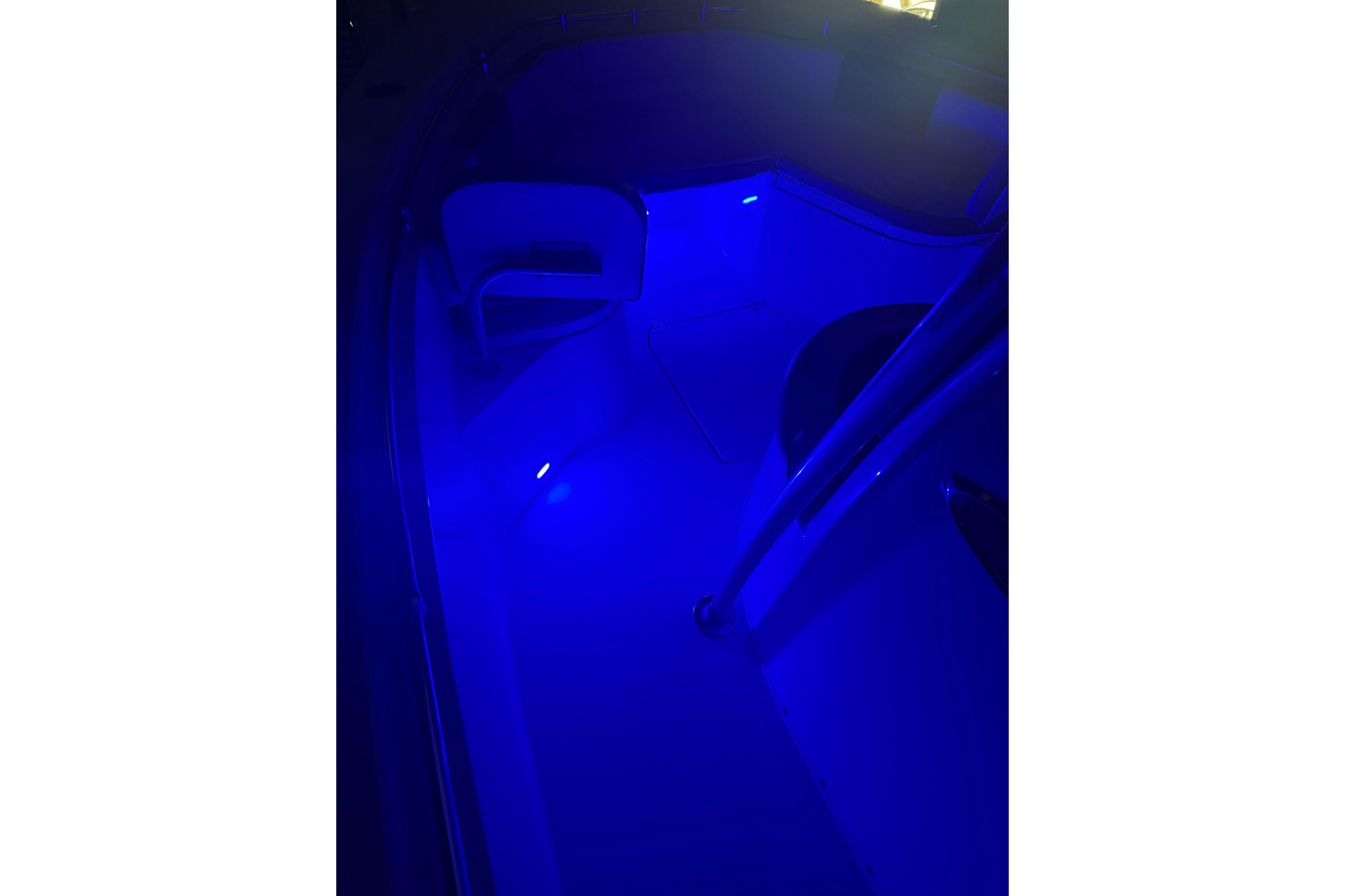 2023 Cobia 237 Center Console boat interior illuminated with blue LED lighting.