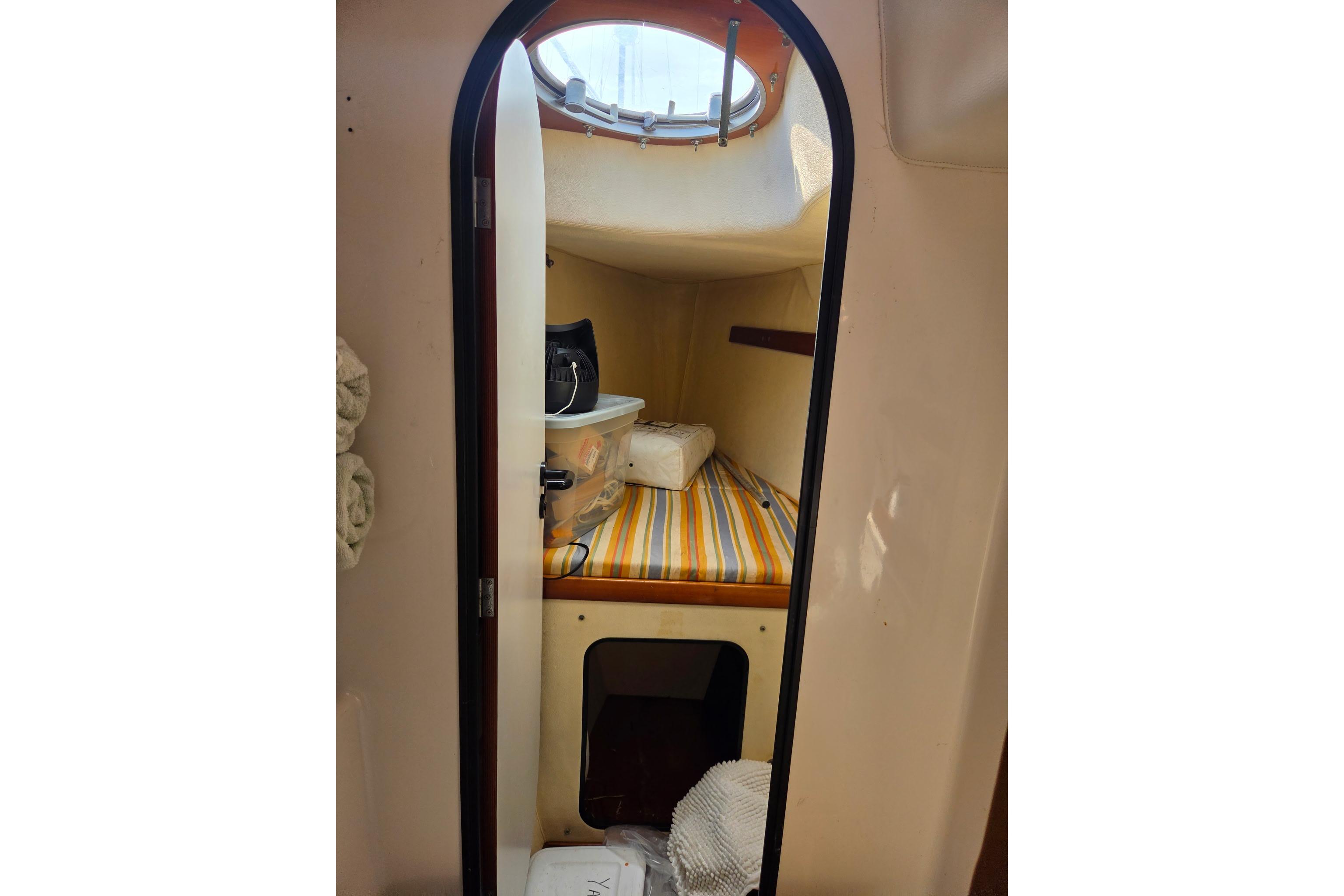 Cabin interior of 2000 Fountaine Pajot Maryland 37 with striped bedding and porthole.