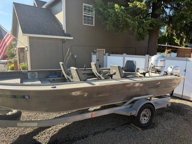 2008 Willie Boats Predator on trailer parked in front of house.