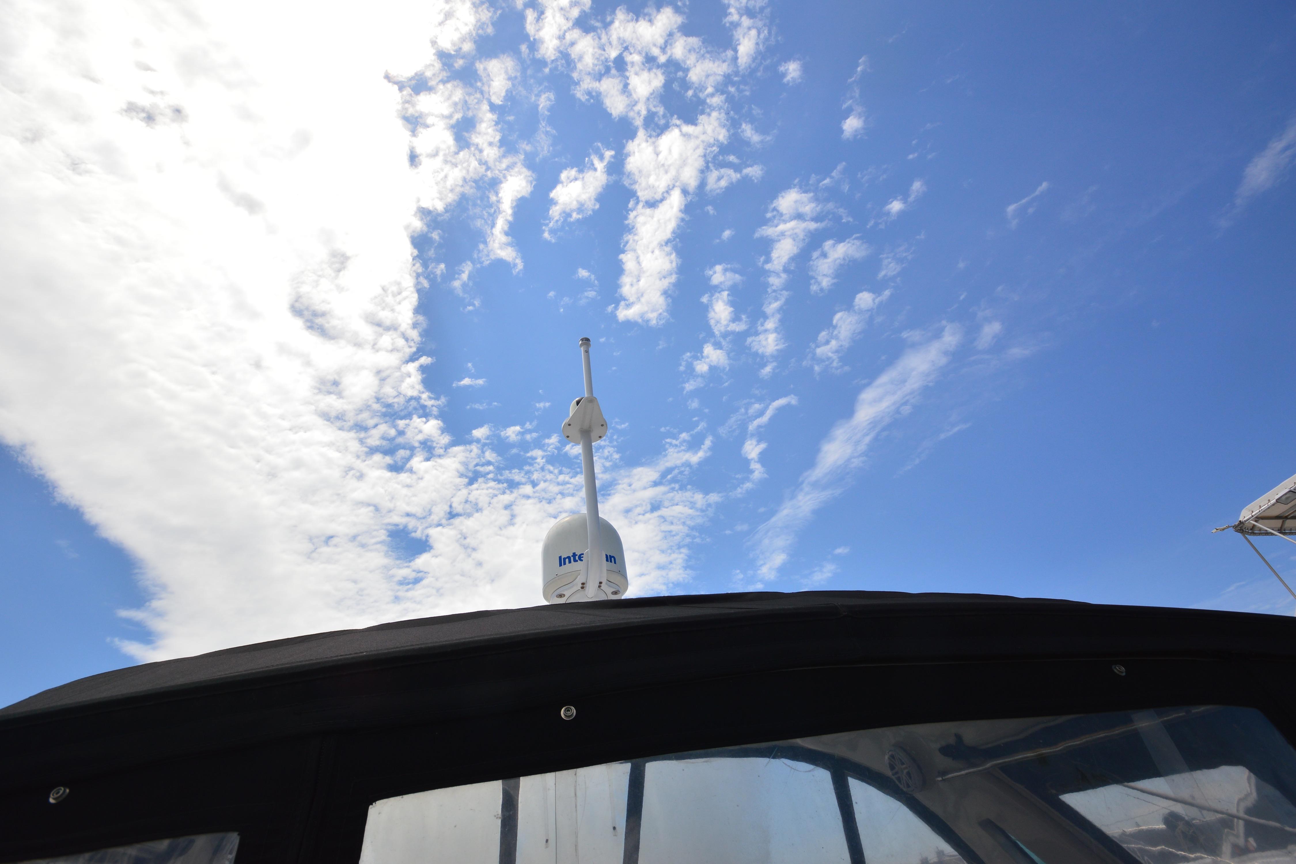 2013 Four Winns V375 boat with radar against a blue sky.