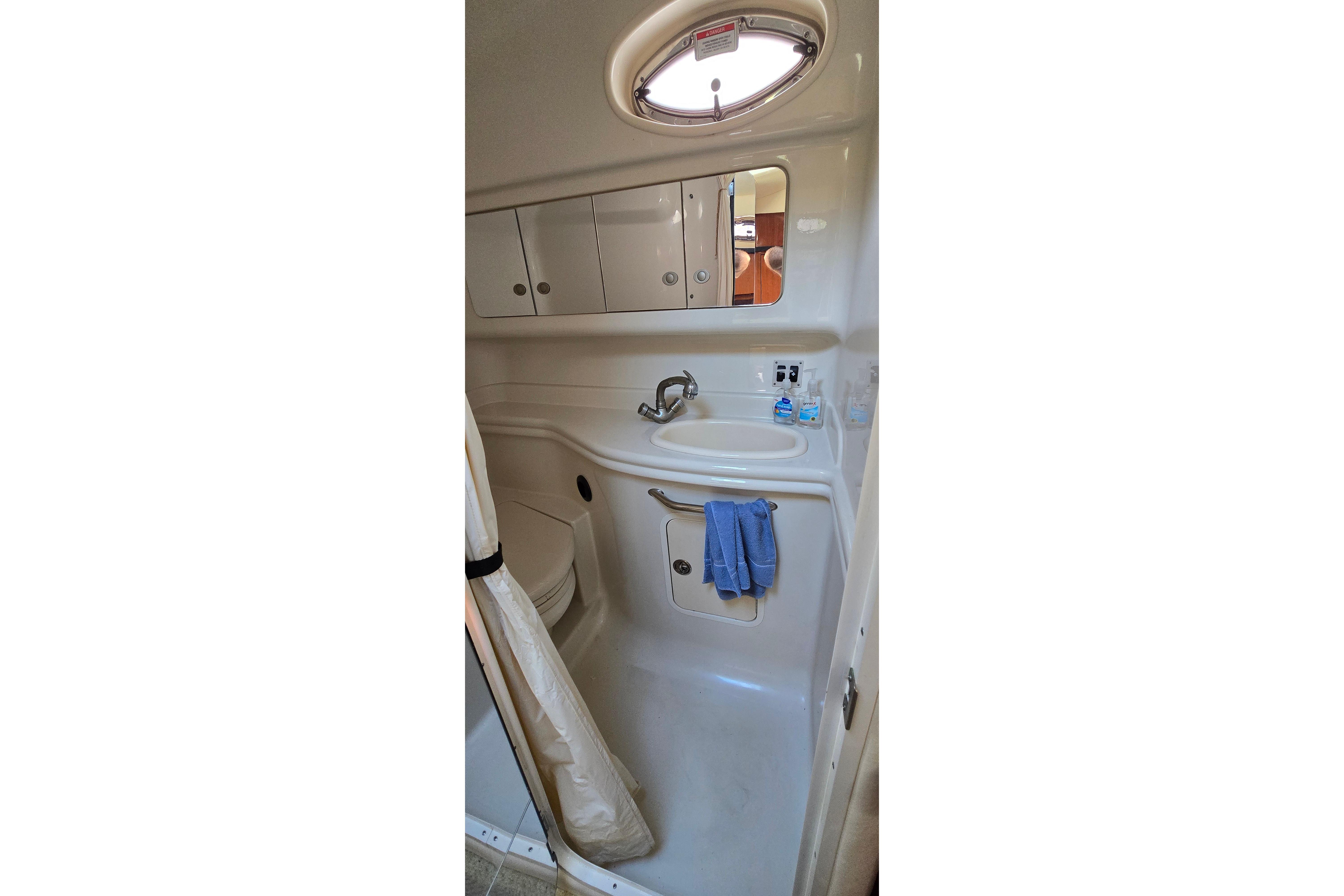 2007 Sea Ray 340 Sundancer bathroom with sink, mirror, and storage cabinets.