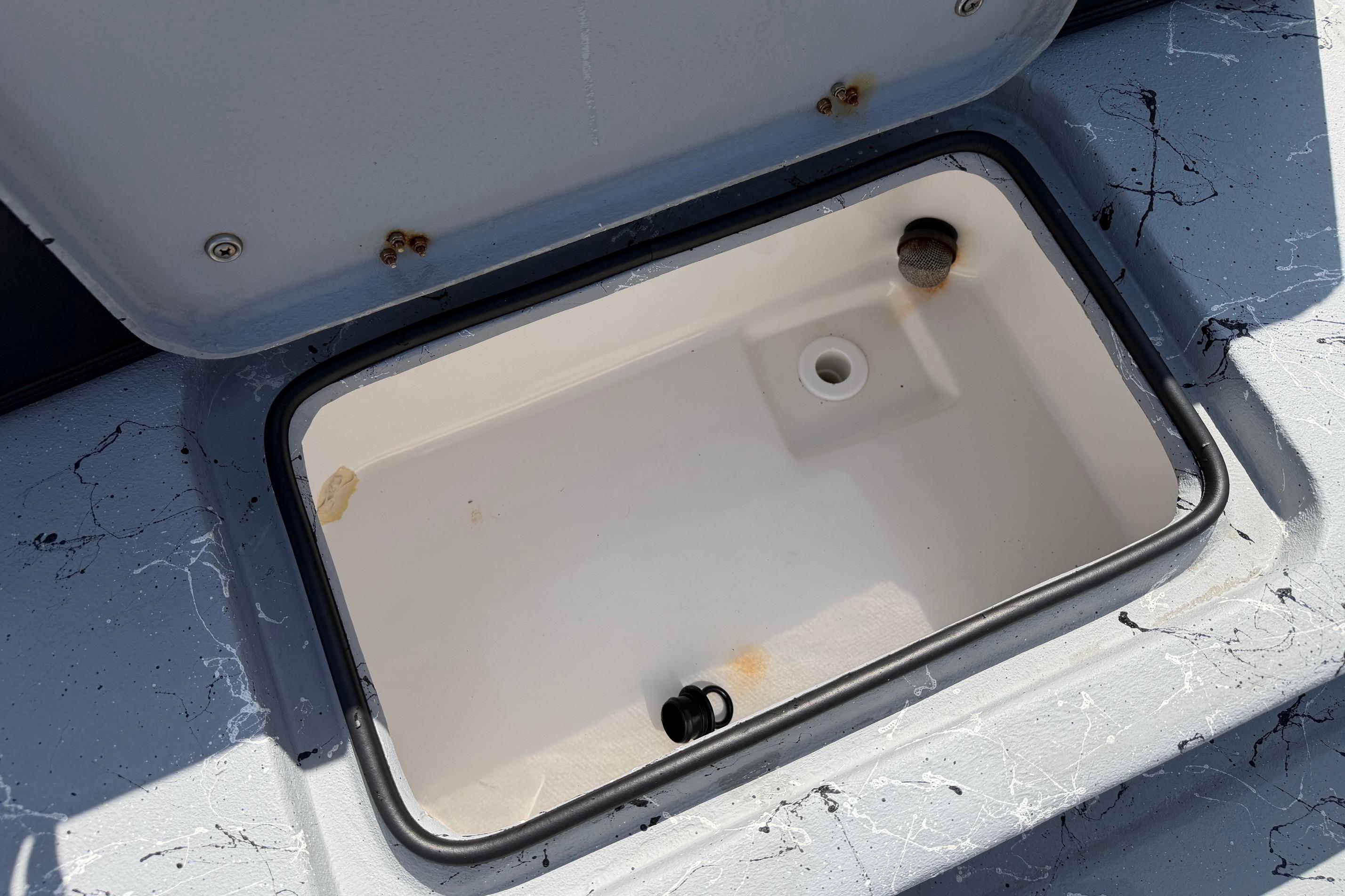 Open storage compartment on 2023 Haynie 23 Super Cat boat, showing interior details.