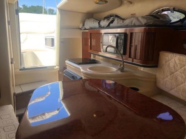 Interior of 2003 Sea Ray 260 Sundancer boat with kitchenette and seating area.