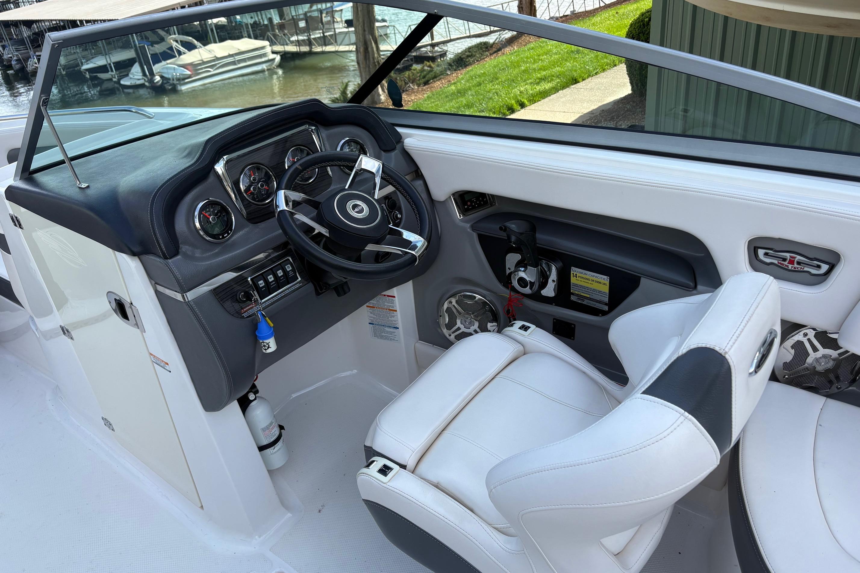 Interior view of 2016 Chaparral 246 SSi boat cockpit with steering wheel and controls.