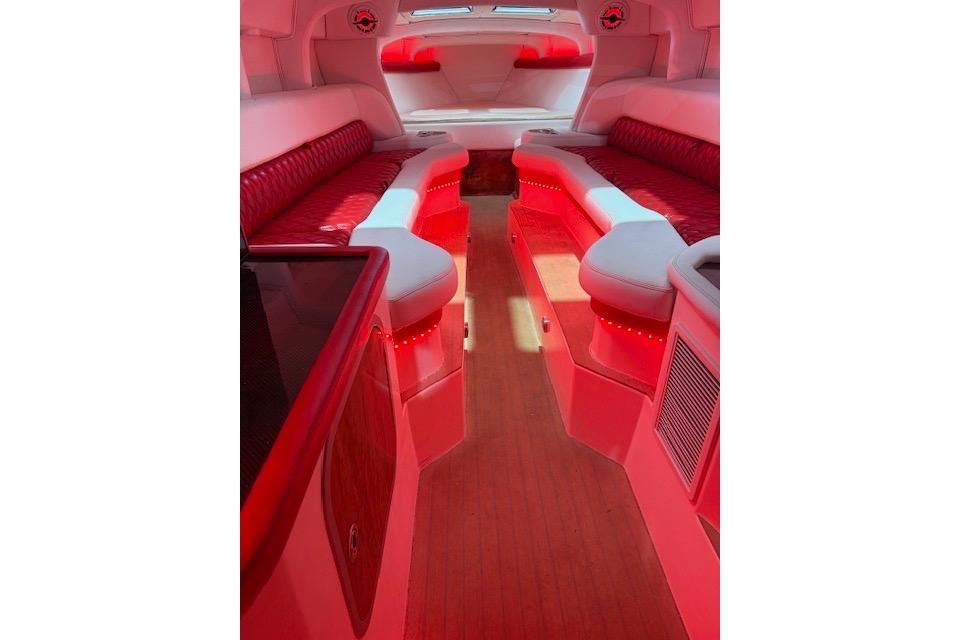 Luxurious interior of a 2007 Nor-Tech 5000V boat with red ambient lighting.