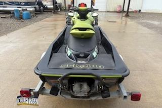 2004 Seadoo Bombardier jet ski on trailer, parked on wet pavement.