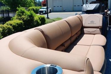Luxurious seating on a 2026 Regency 250 DL boat, featuring plush tan upholstery and cup holders.