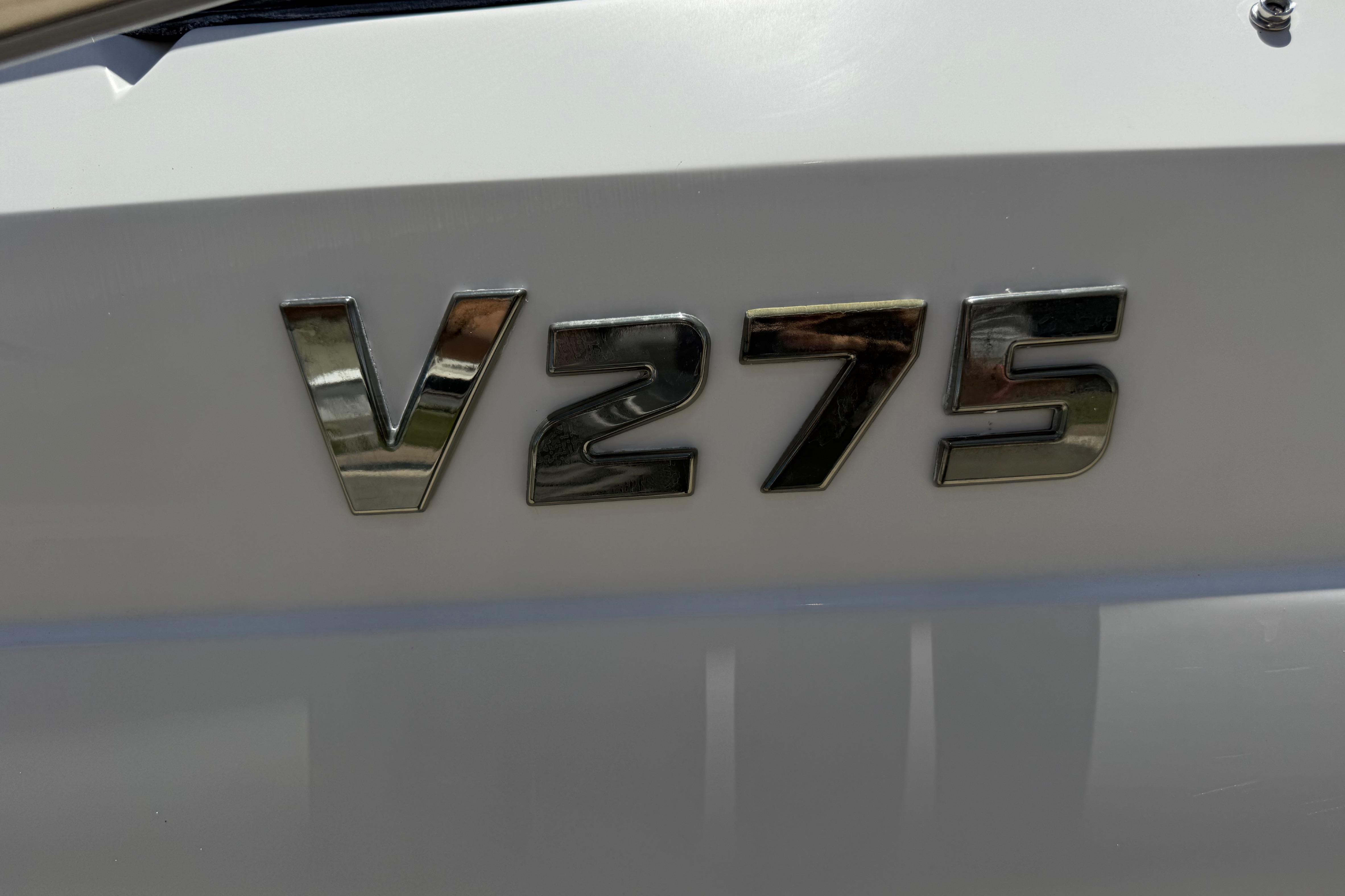 Chrome "V275" emblem on a 2017 Four Winns boat hull.
