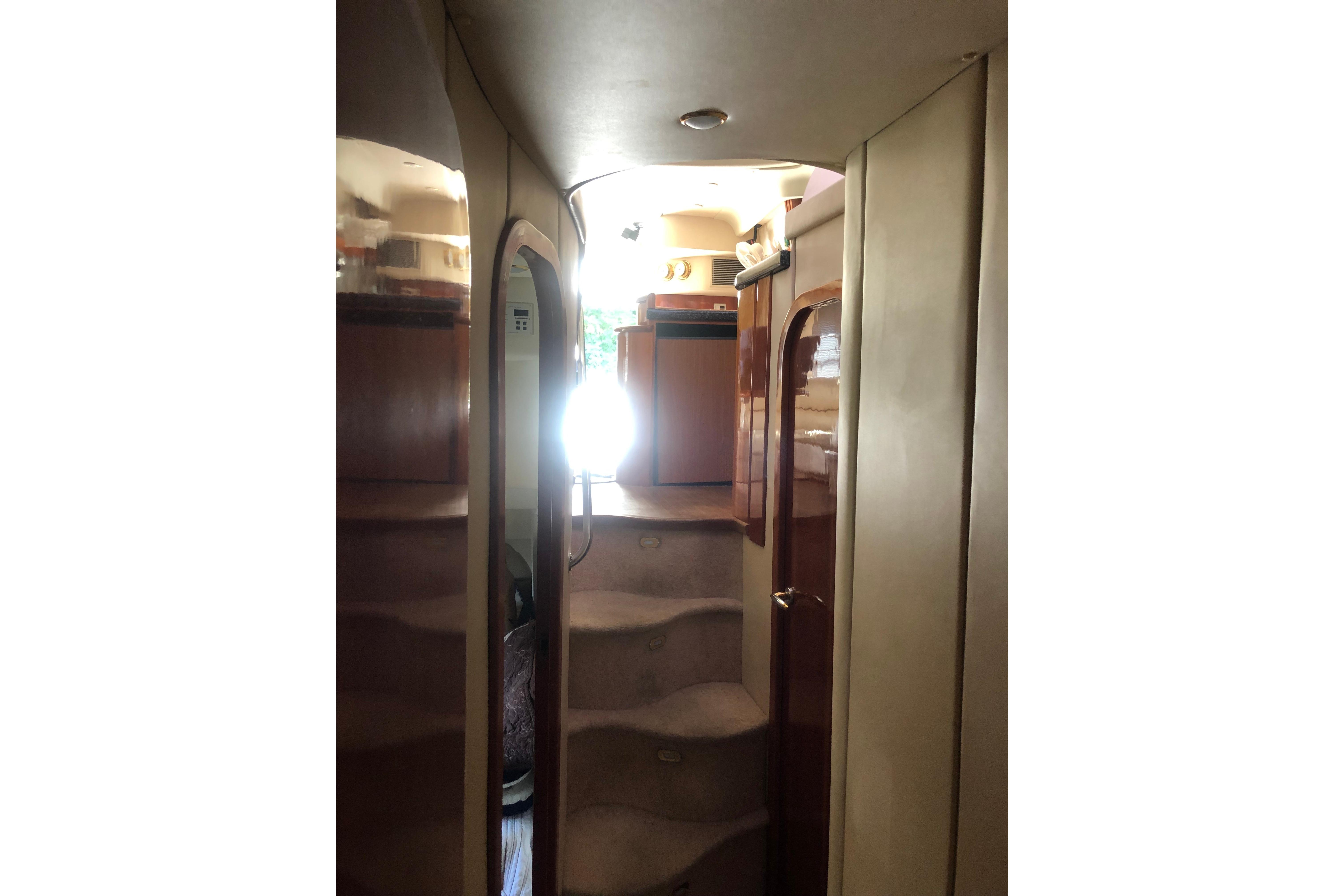 Interior view of 2002 Birchwood Challenger 460 Flybridge yacht with staircase and wooden finishes.