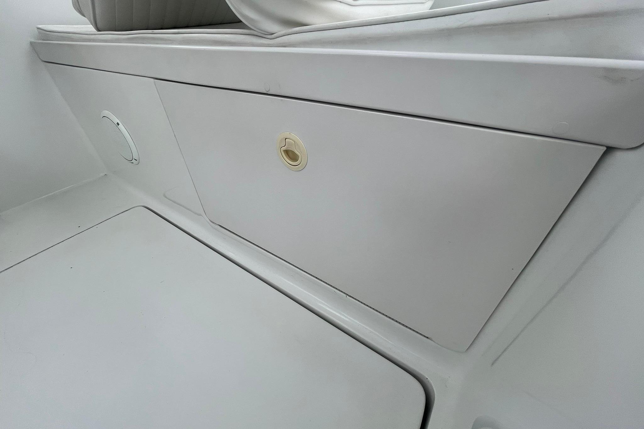 Storage compartment on a 1996 Luhrs Tournament 290 Open boat, featuring sleek white design.