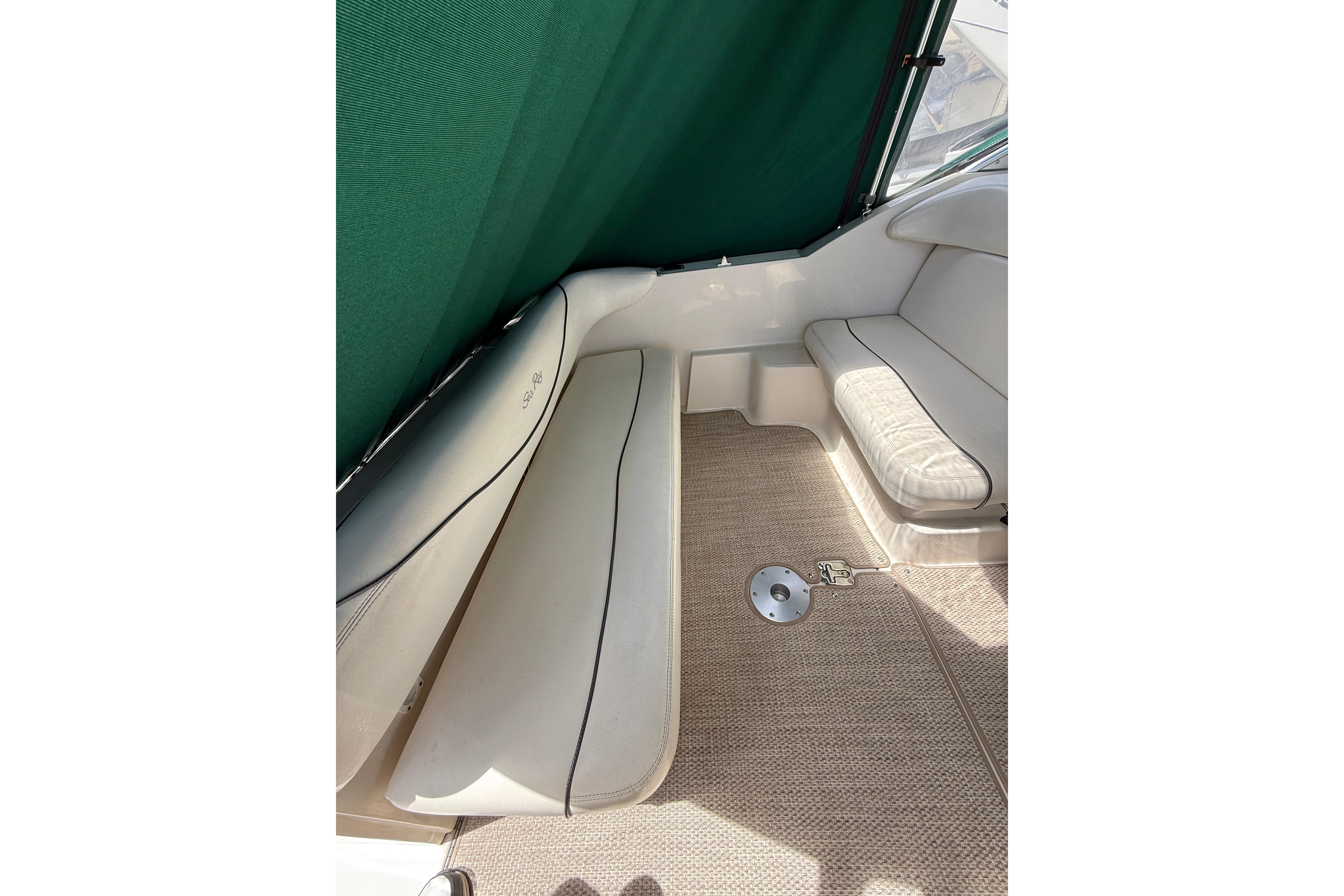 Interior seating of 2004 Sea Ray 240 Sundancer boat with green canopy.