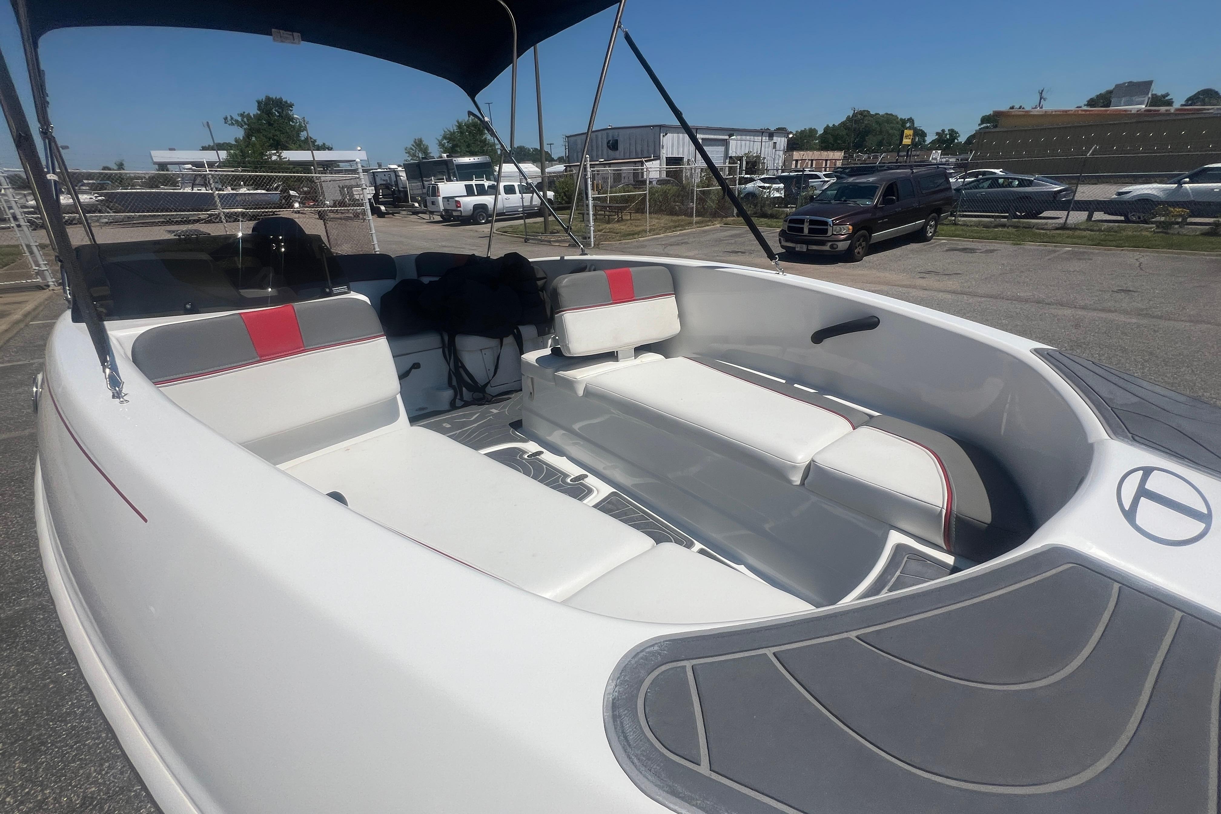 2023 Tahoe T16 boat with white and red seating, parked outdoors.