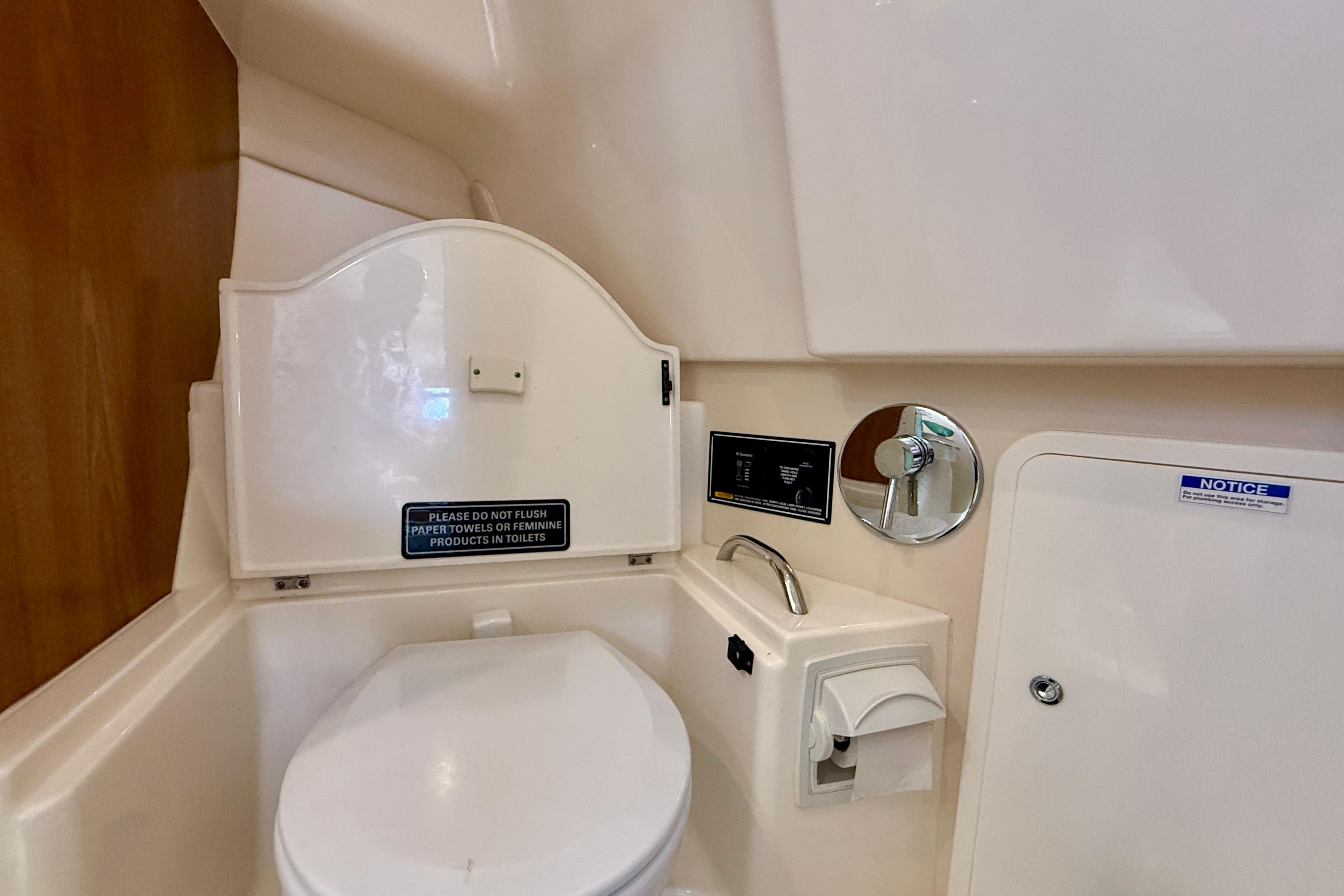 2012 Pursuit OS 345 Offshore boat bathroom with toilet and warning signs.