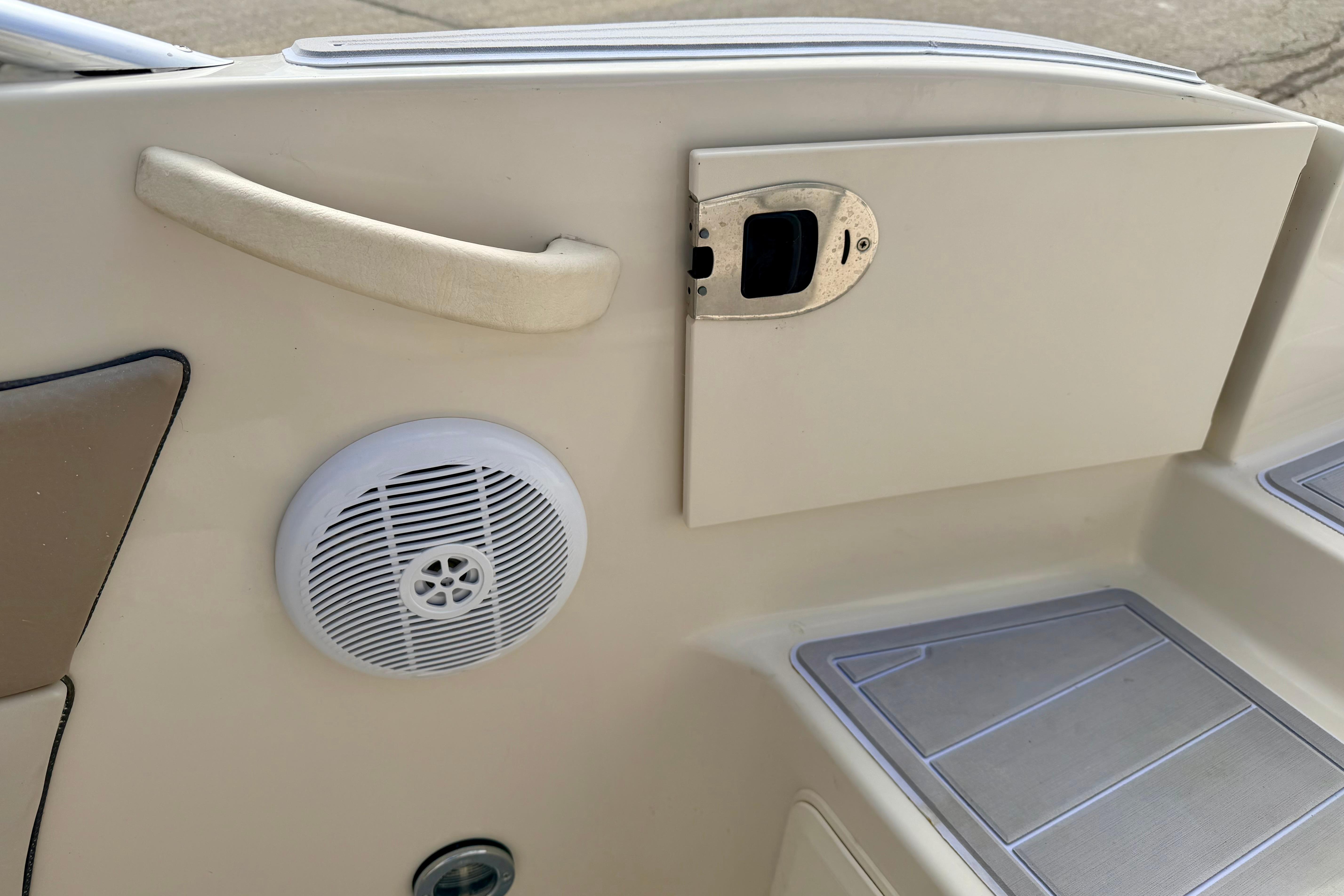 Interior of 2003 Sea Ray 200 Sundeck showing speaker, handle, and storage compartment.
