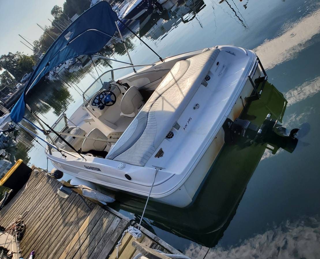 A 2006 Glastron MX-195 Limited Edition docked. It features a blue sunshade.