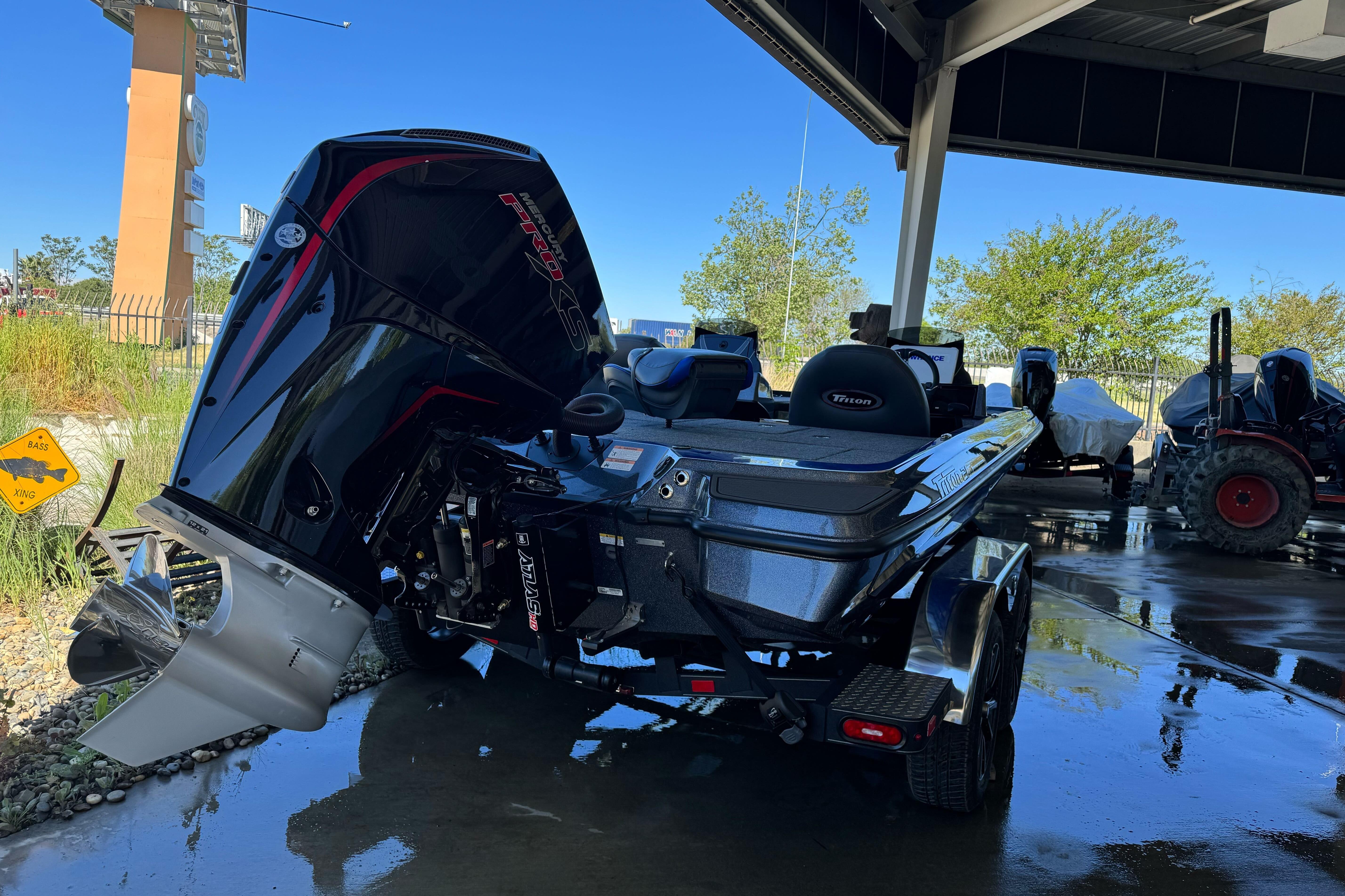 2026 Triton 21XP Patriot boat with powerful outboard motor in a showroom setting.