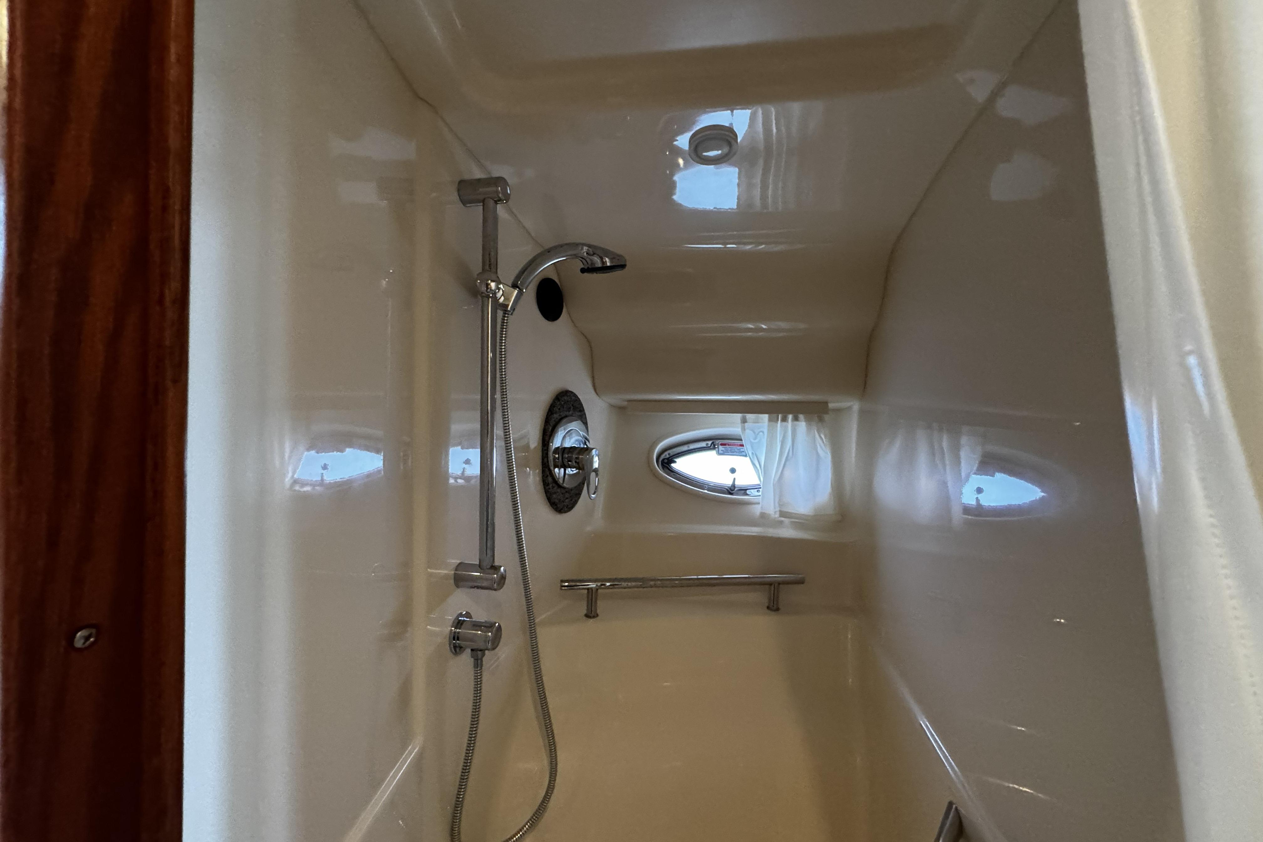 Shower area inside 2006 Sea Ray 40 Sundancer yacht with porthole window.