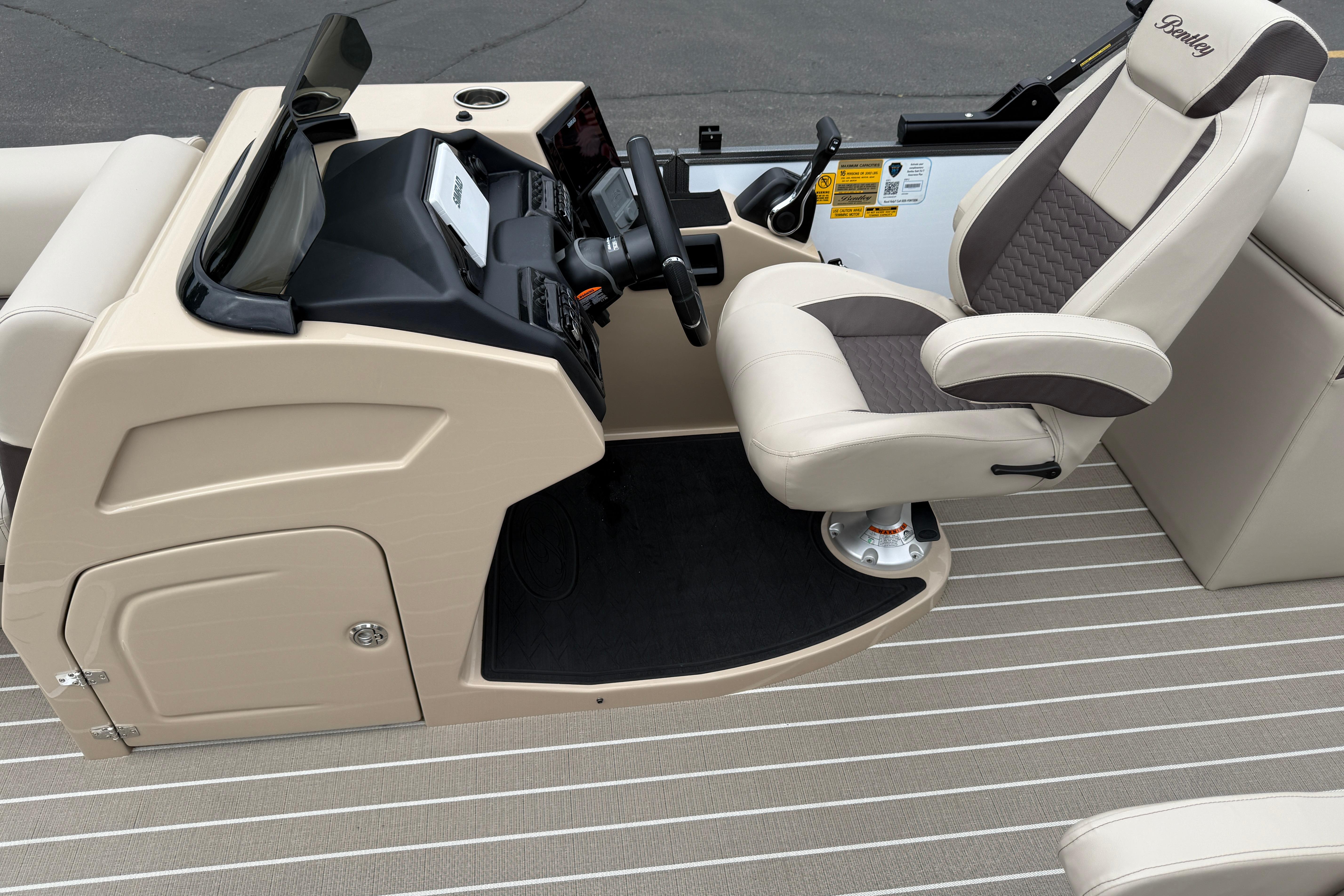 2026 Bentley Pontoons Elite 253 Admiral helm with luxurious captain's chair and modern dashboard.