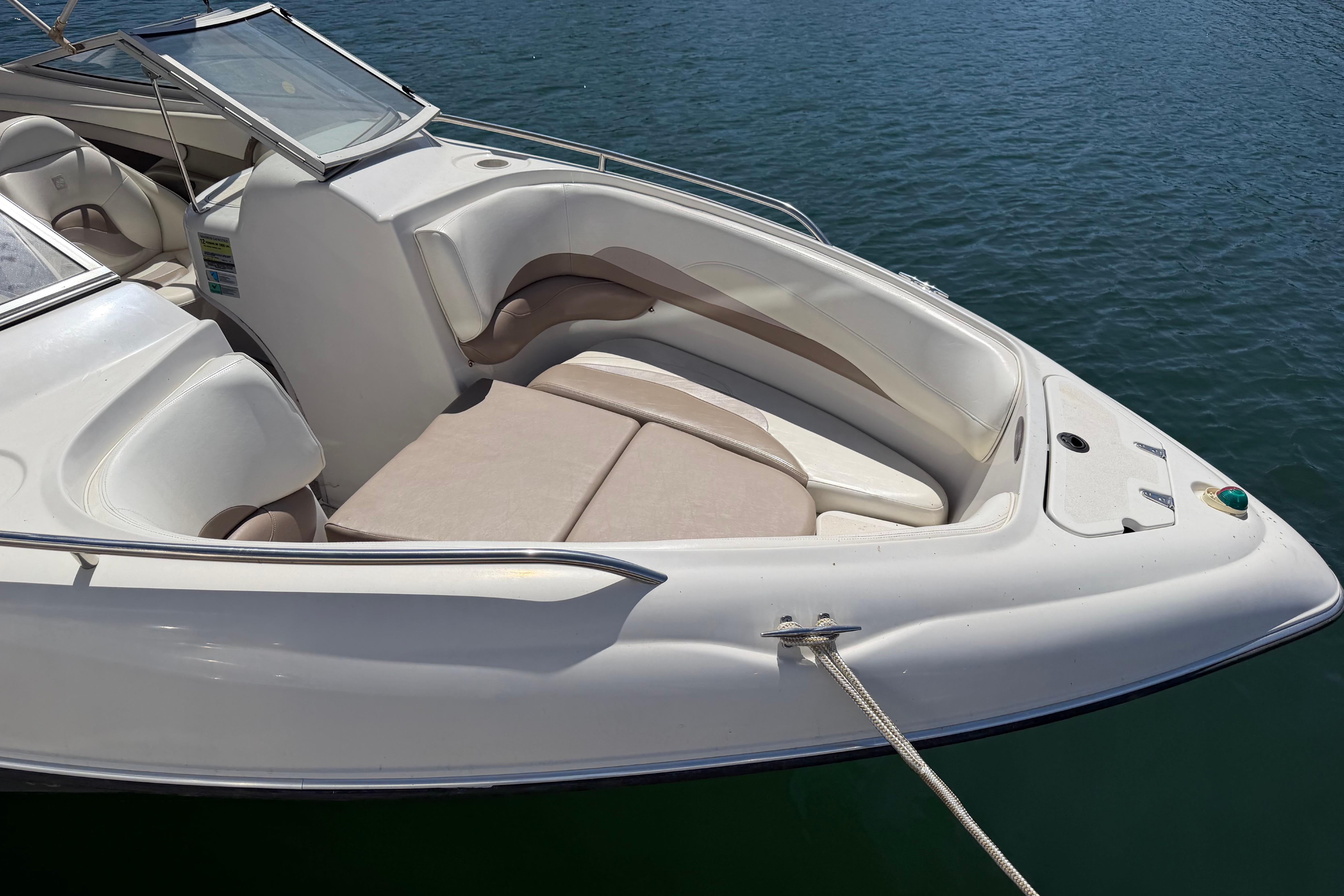 1998 Four Winns 220 Horizon boat with spacious seating, docked on calm water.