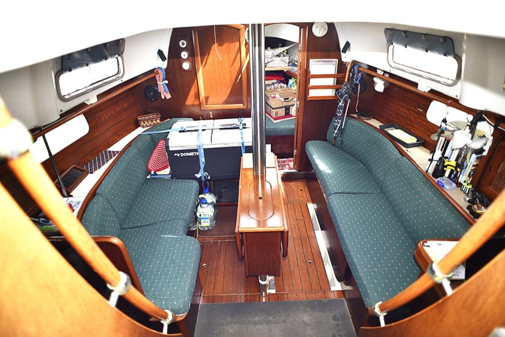Interior of 1999 Beneteau 36 Oceanis CC sailboat with green seating and wooden finishes.