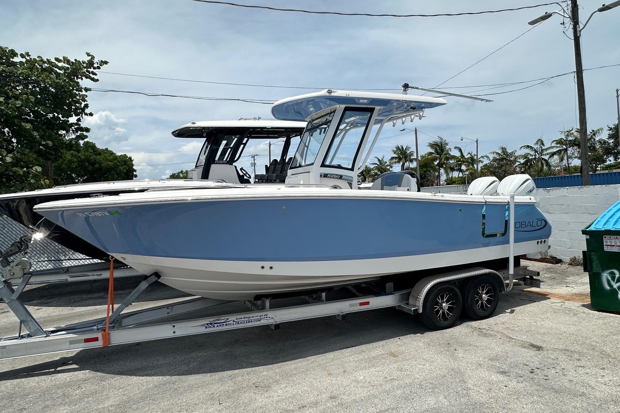 2024 Robalo R250 Center Console boat on trailer, blue and white design.
