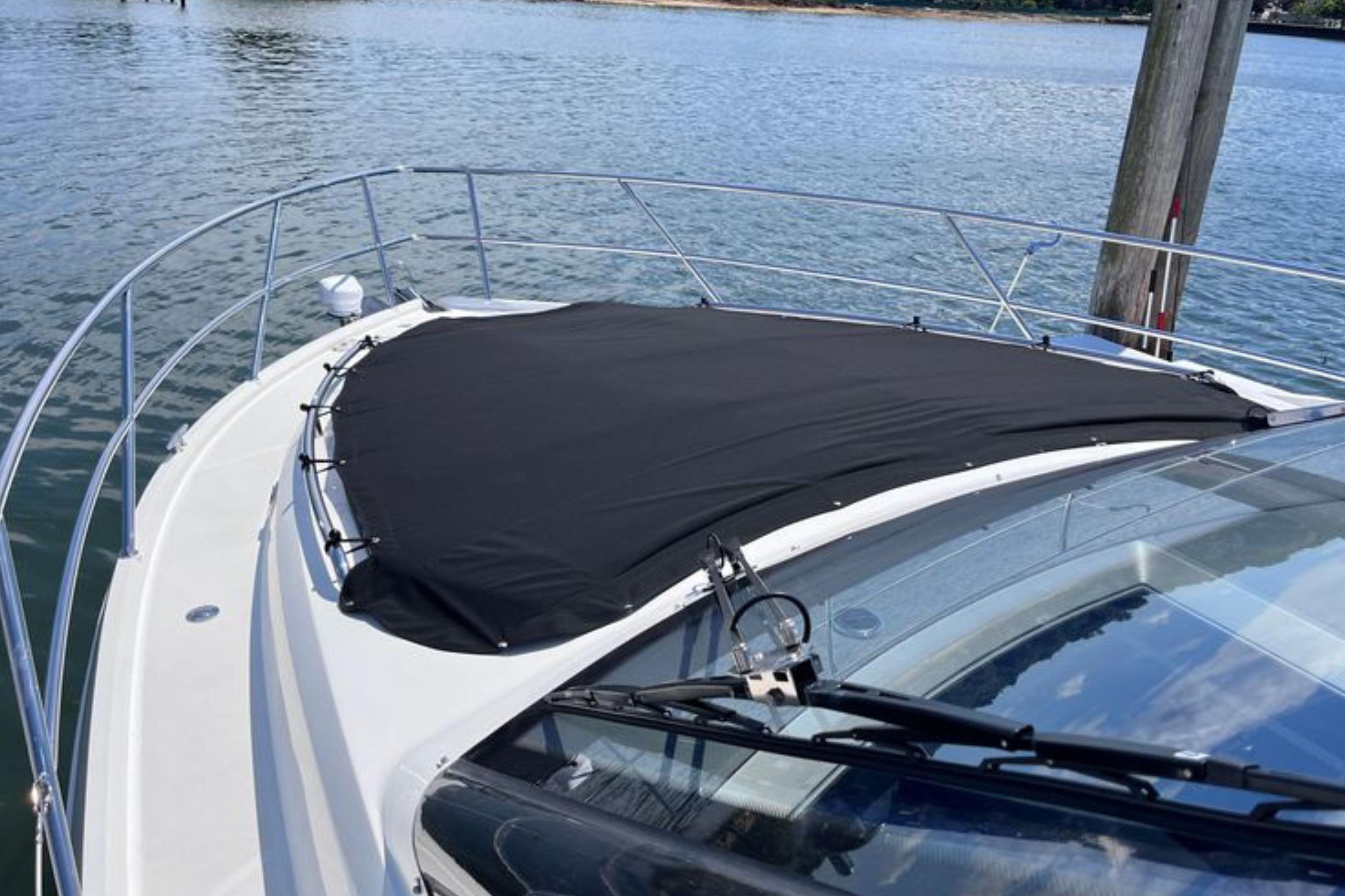 2024 Galeon 425 HTS yacht with black cover on deck, docked by calm waters.