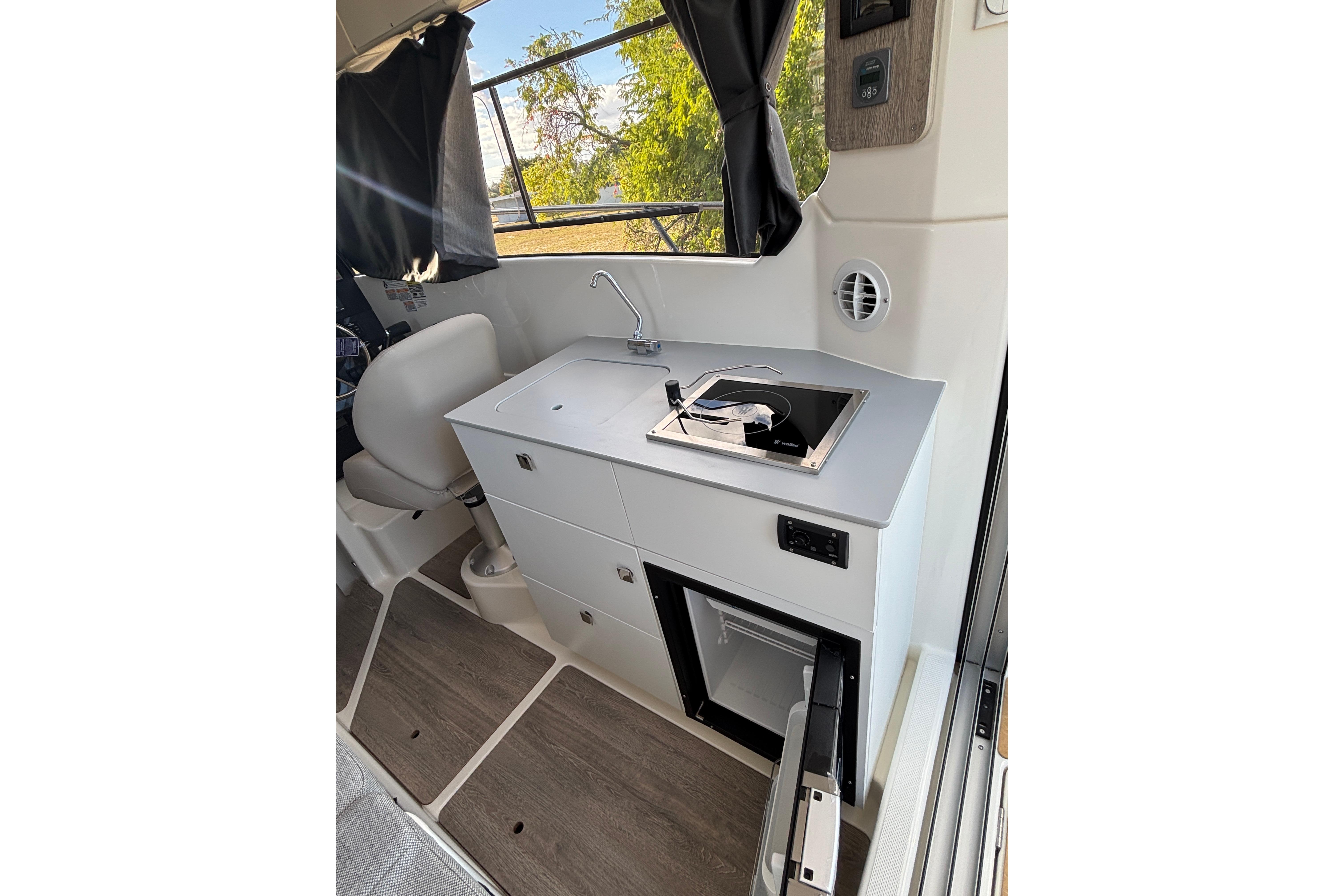 Compact kitchen area in 2026 Trophy T 25 Explorer boat with sink and stove.