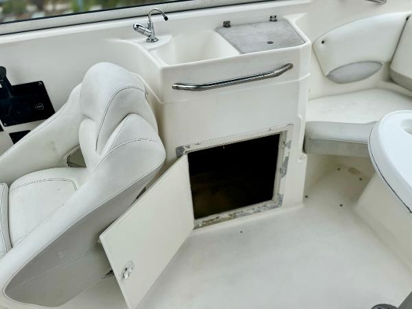 2006 Larson LXi 248 boat interior with open storage compartment and sink.