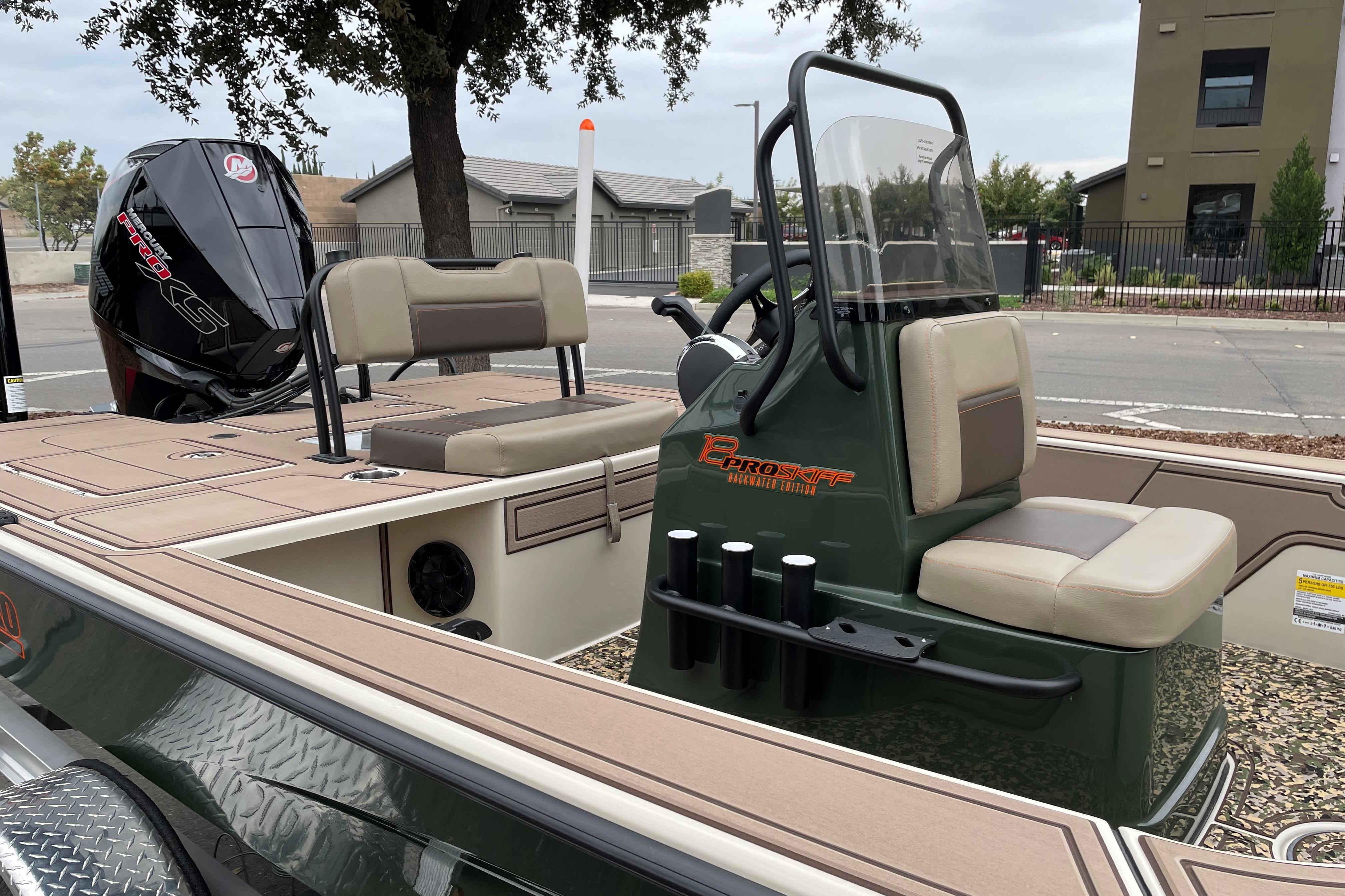 2025 Mako 18 Pro Skiff Backwater Edition boat with seating and console, parked outdoors.