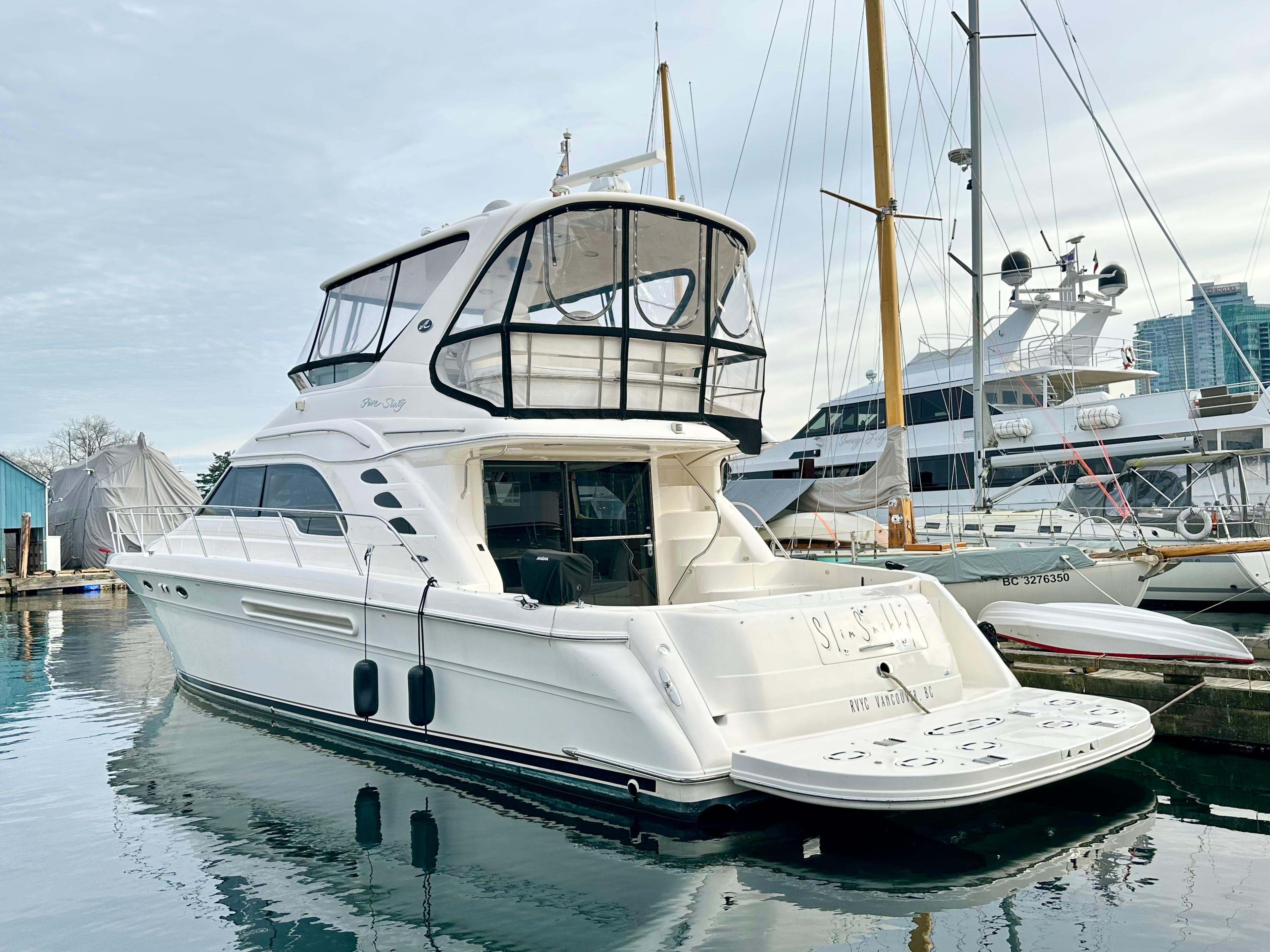 2002 Sea Ray 560 Sedan Bridge yacht docked in a marina, showcasing sleek design and spacious deck.