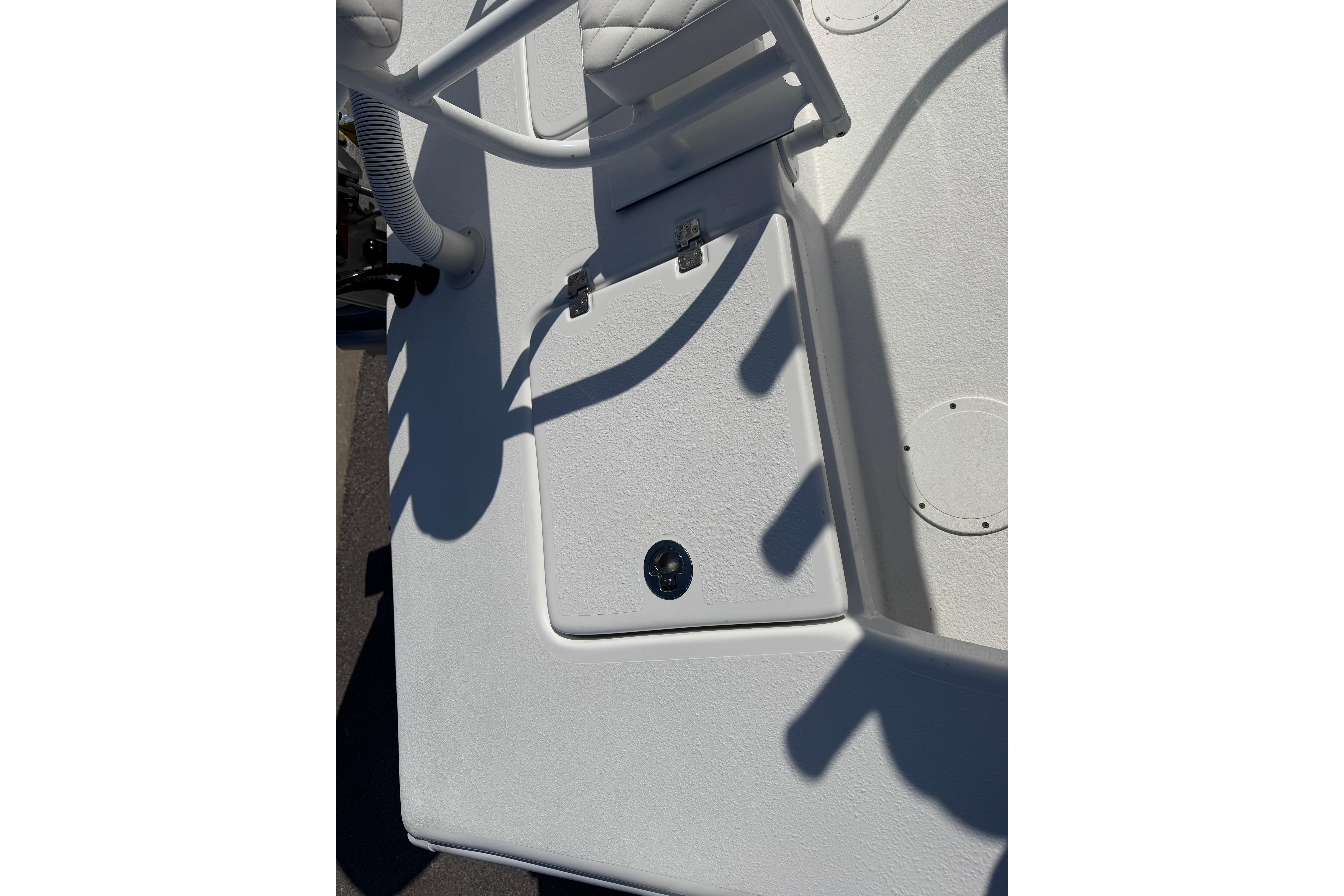 2026 Skuta 24 Cat boat deck with storage compartment and seating.