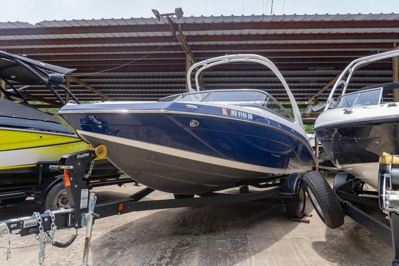 2021 Yamaha Boats 195S, blue hull, on trailer under shelter.