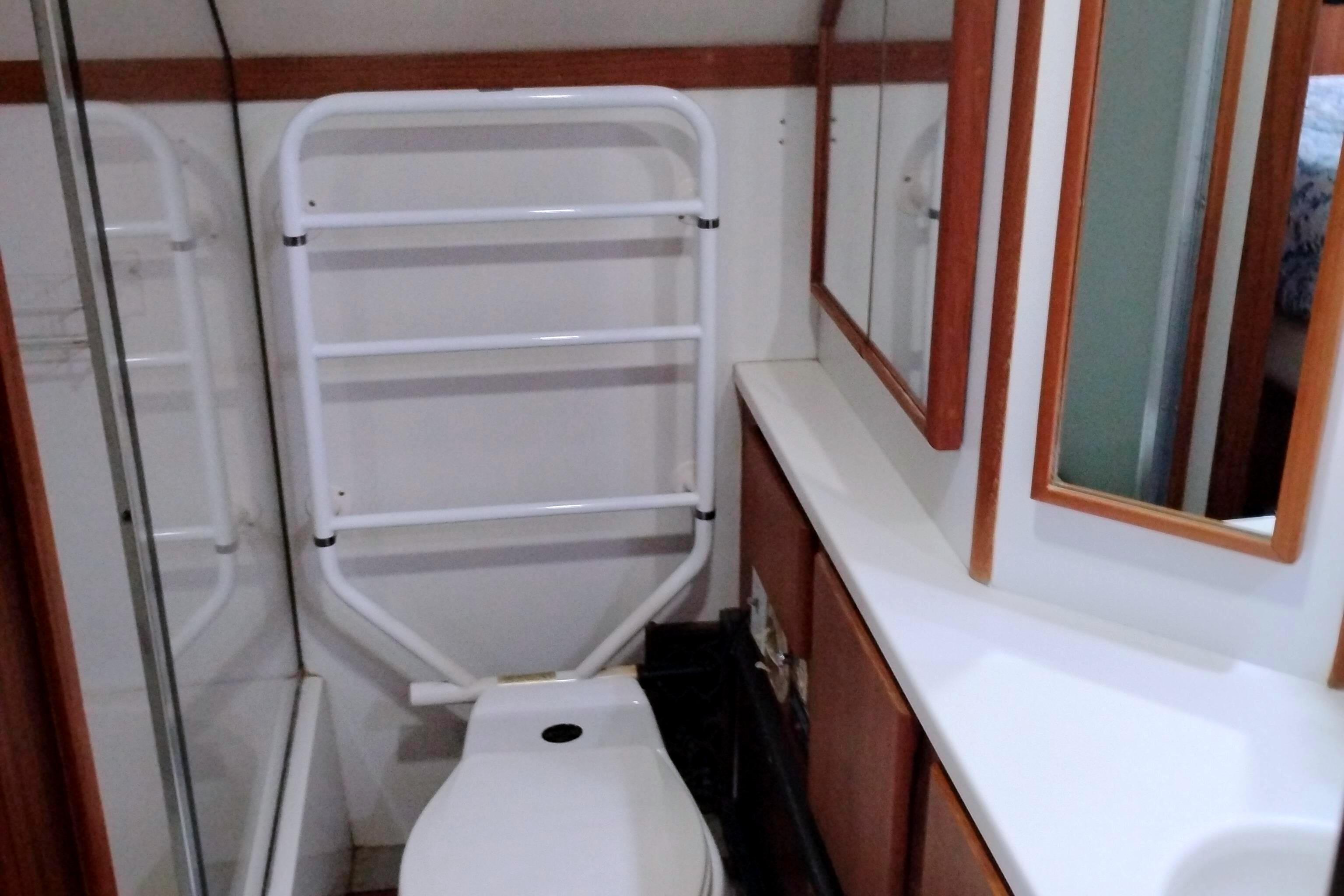 Bathroom interior of 1991 Californian 52 Cockpit Motor Yacht with toilet and mirror.
