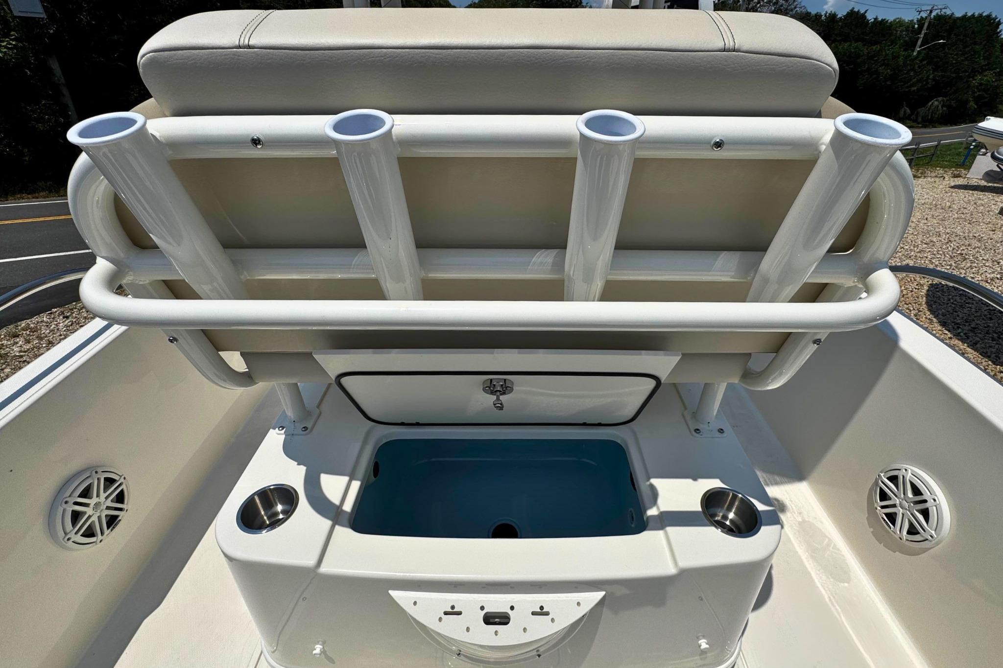 Boston Whaler 220 Dauntless 2026 boat seating with rod holders and storage compartment.