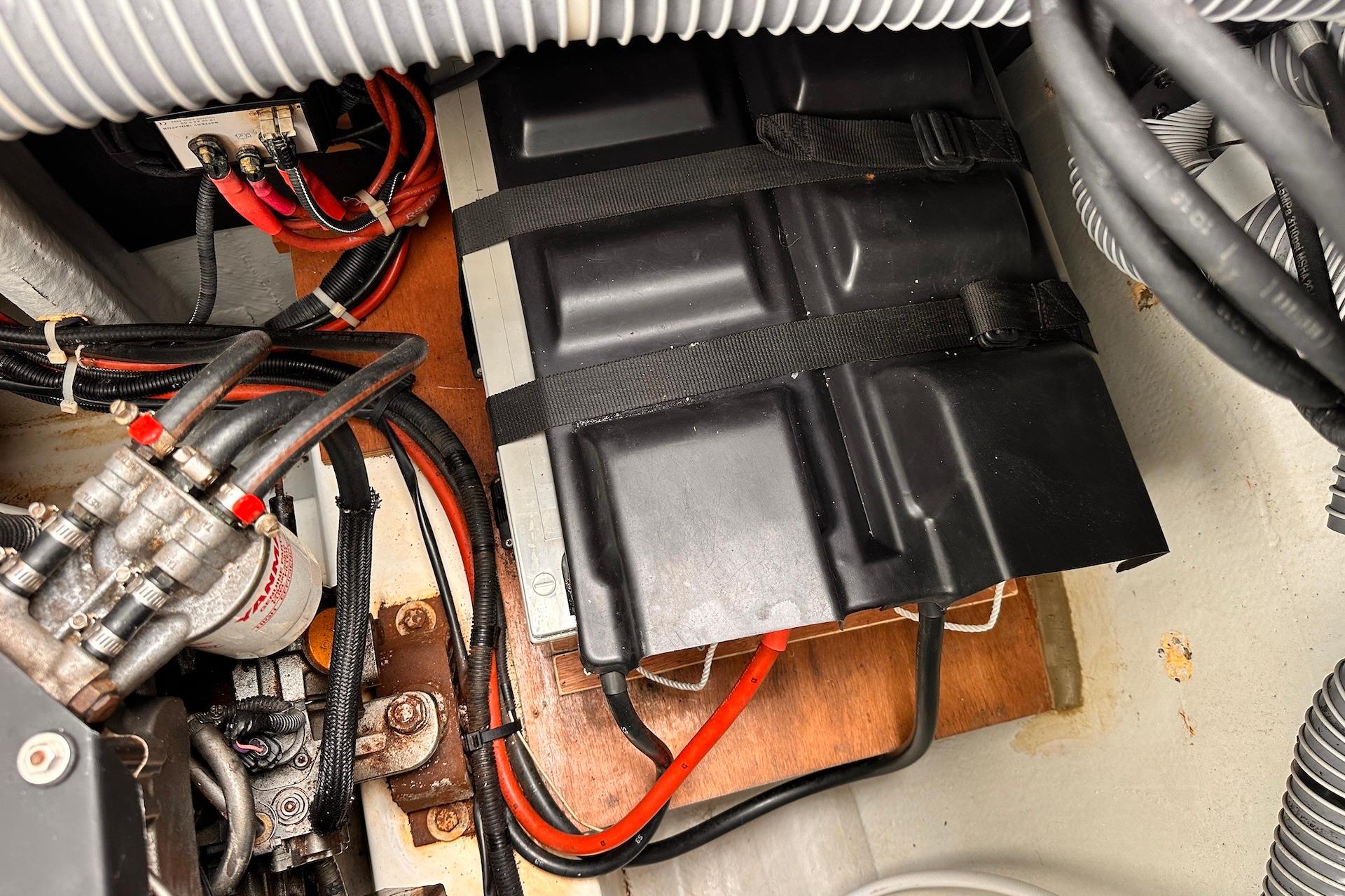 Engine compartment of a 2016 Lagoon 42 catamaran, showing battery and wiring setup.