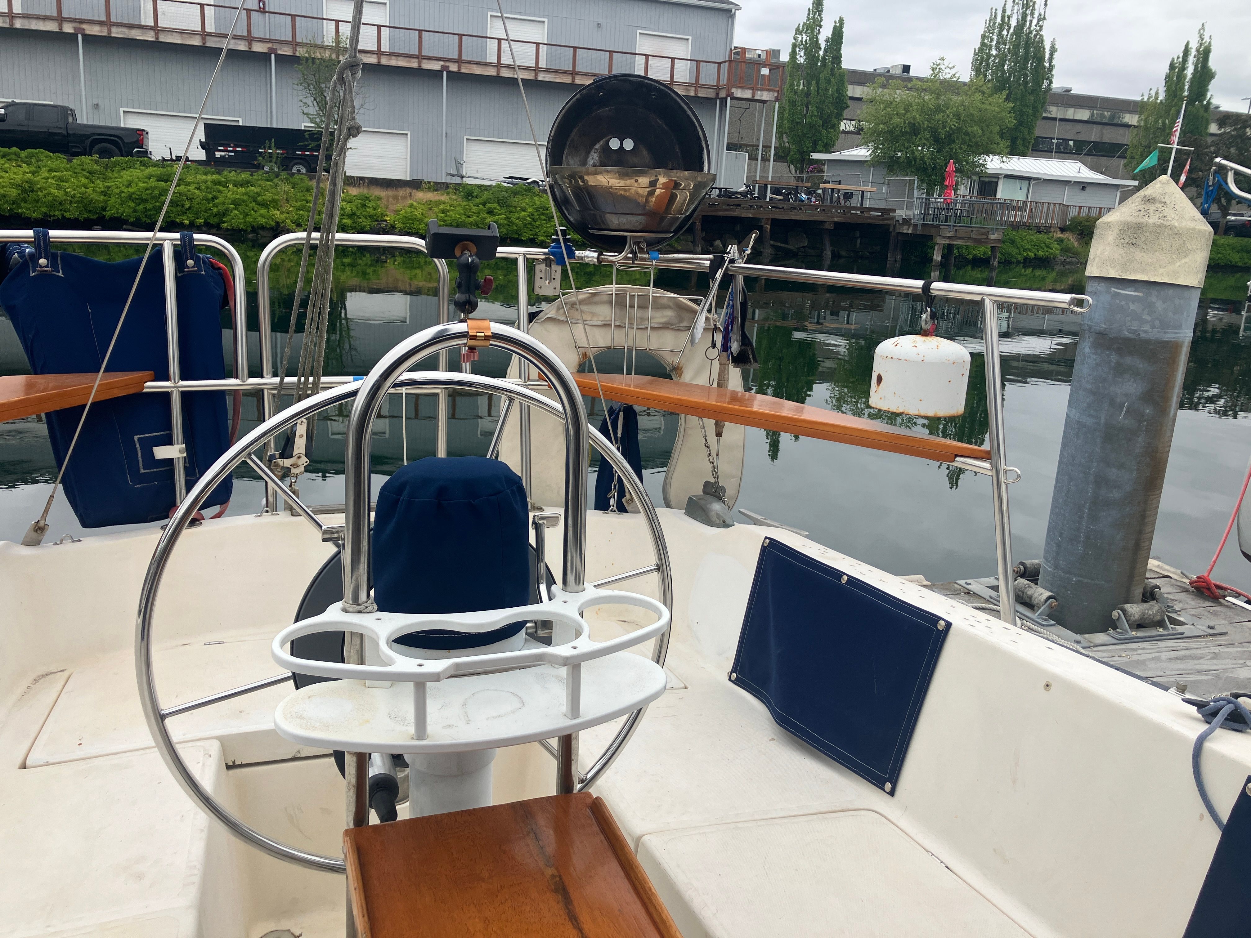 The cockpit of a 1984 Catalina 30 with a steering wheel and blue cushions.