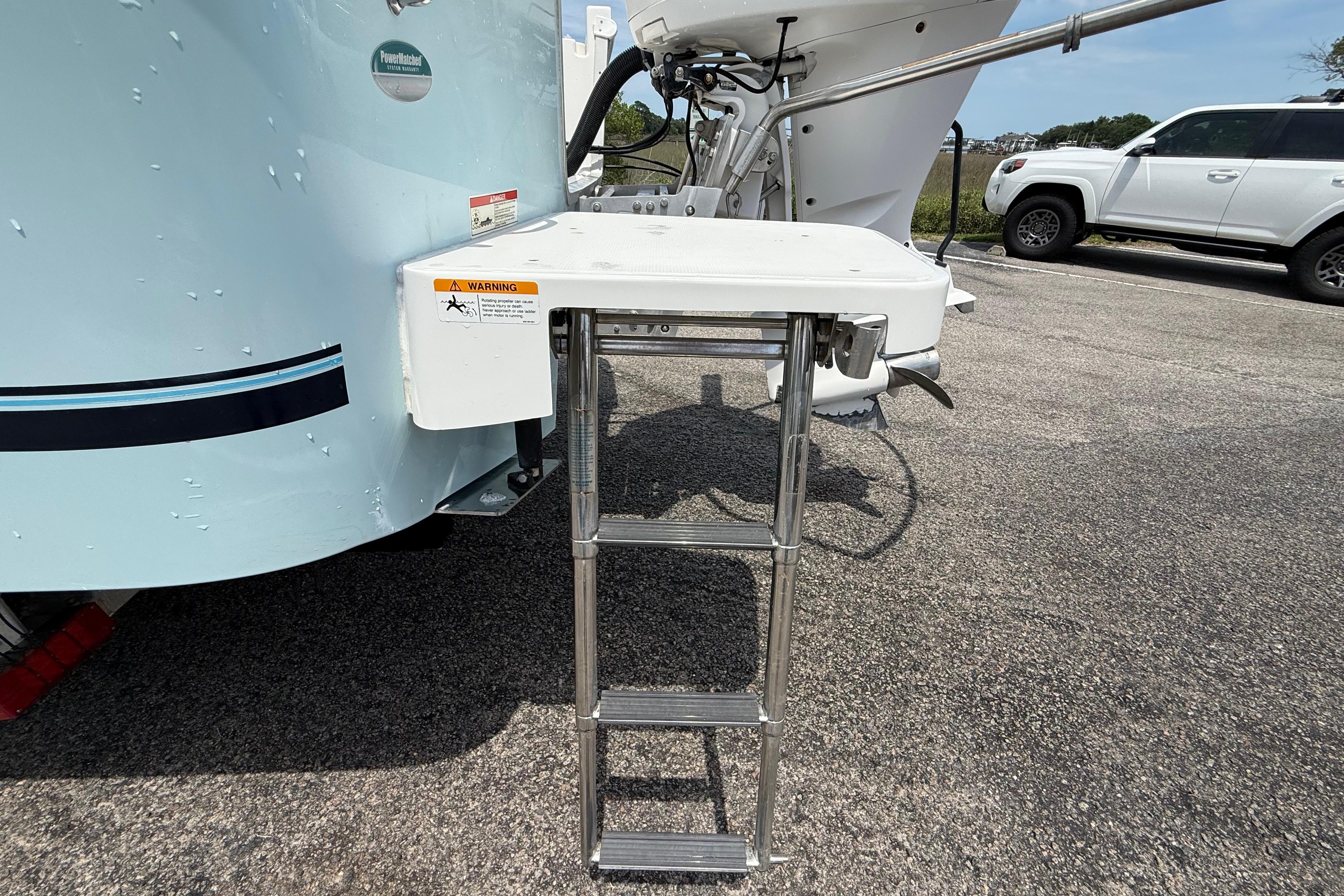 2019 Regulator 26XO boat with a foldable swim ladder on a sunny day.