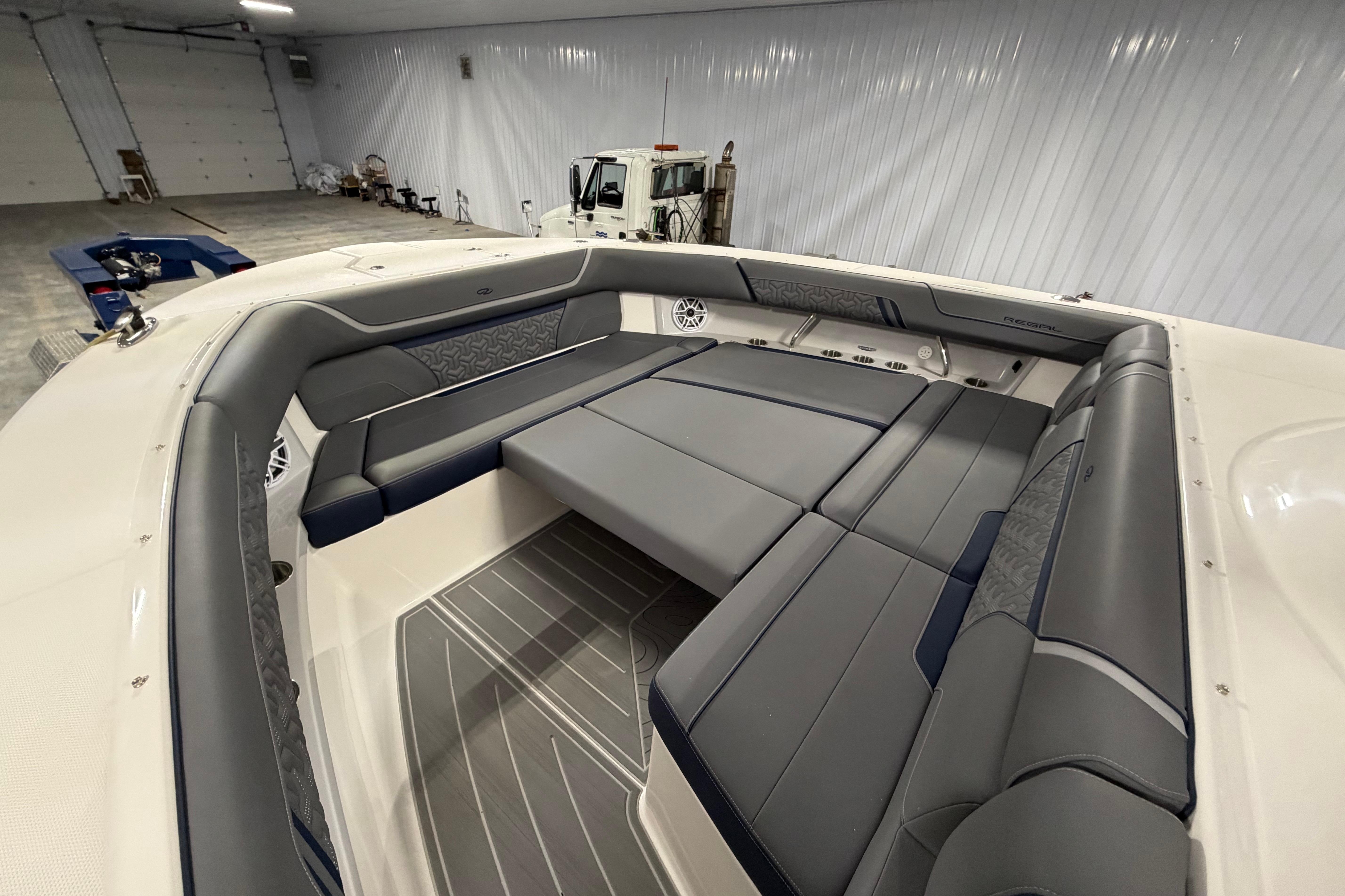 Luxurious interior of 2027 Regal 38 Surf boat with spacious seating in a garage.