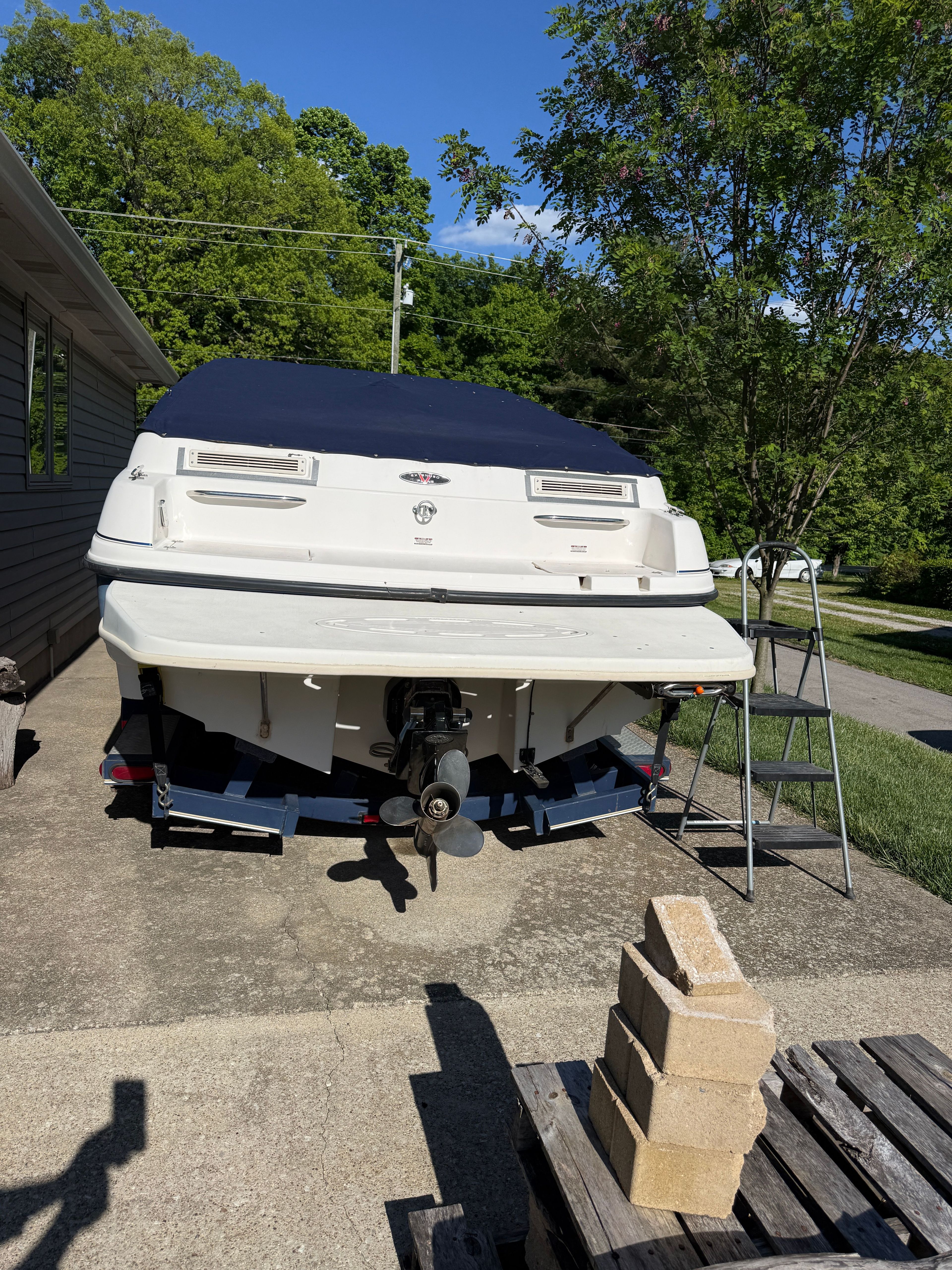 1999 Custom 2335 Cuddy Cabin boat on trailer in driveway.