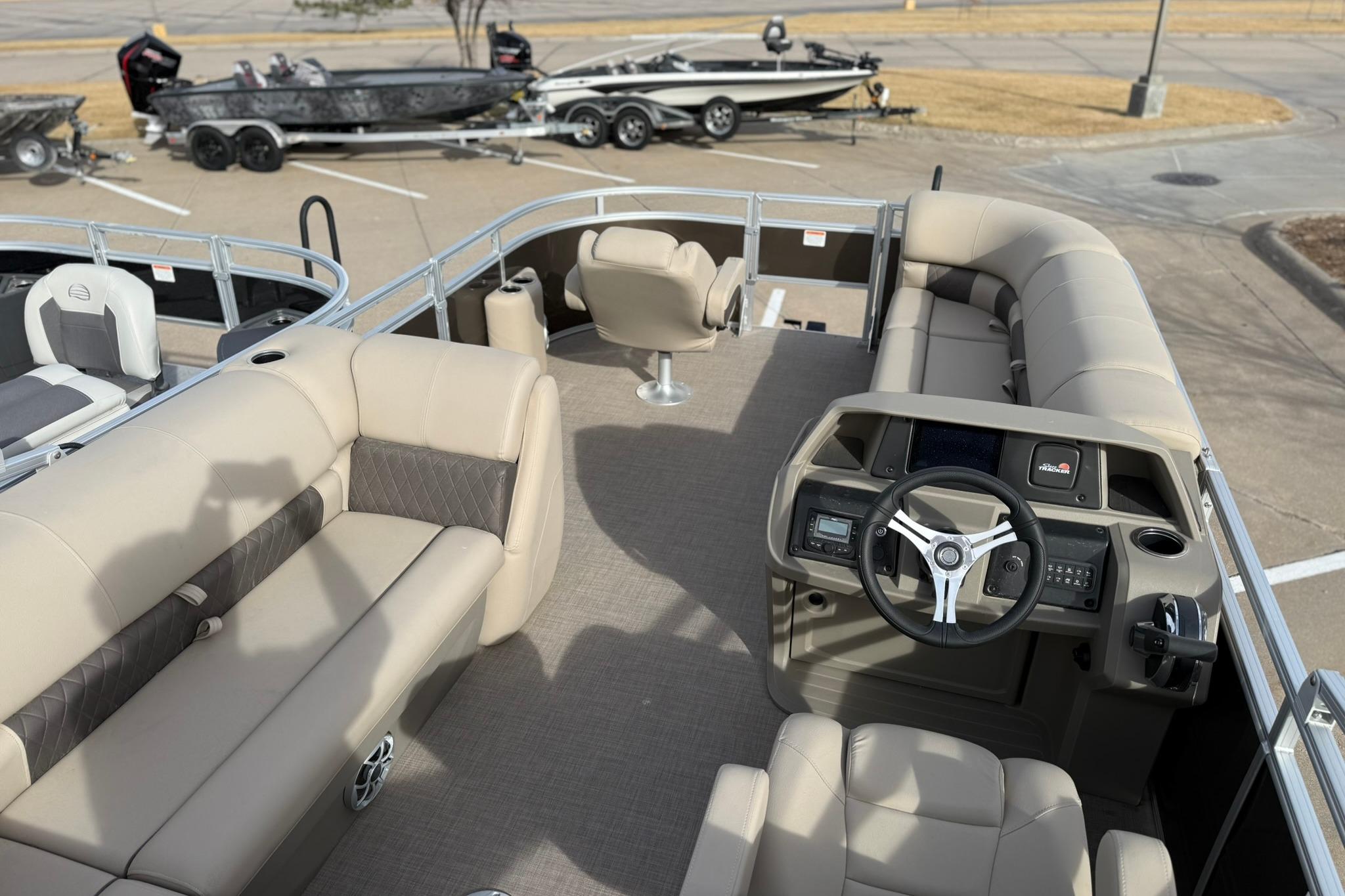 2025 Sun Tracker SportFish 20 DLX pontoon boat interior with steering console and seating.