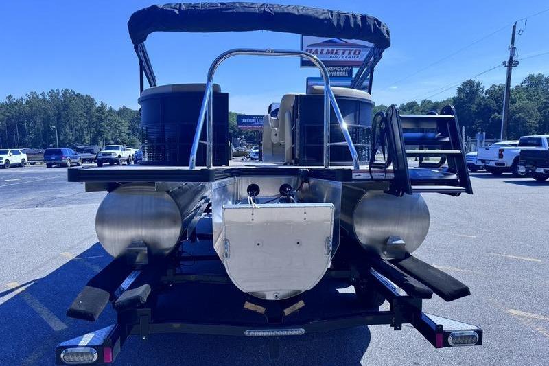2027 Manitou Aurora 23 RF SHP pontoon boat on trailer, rear view in parking lot.