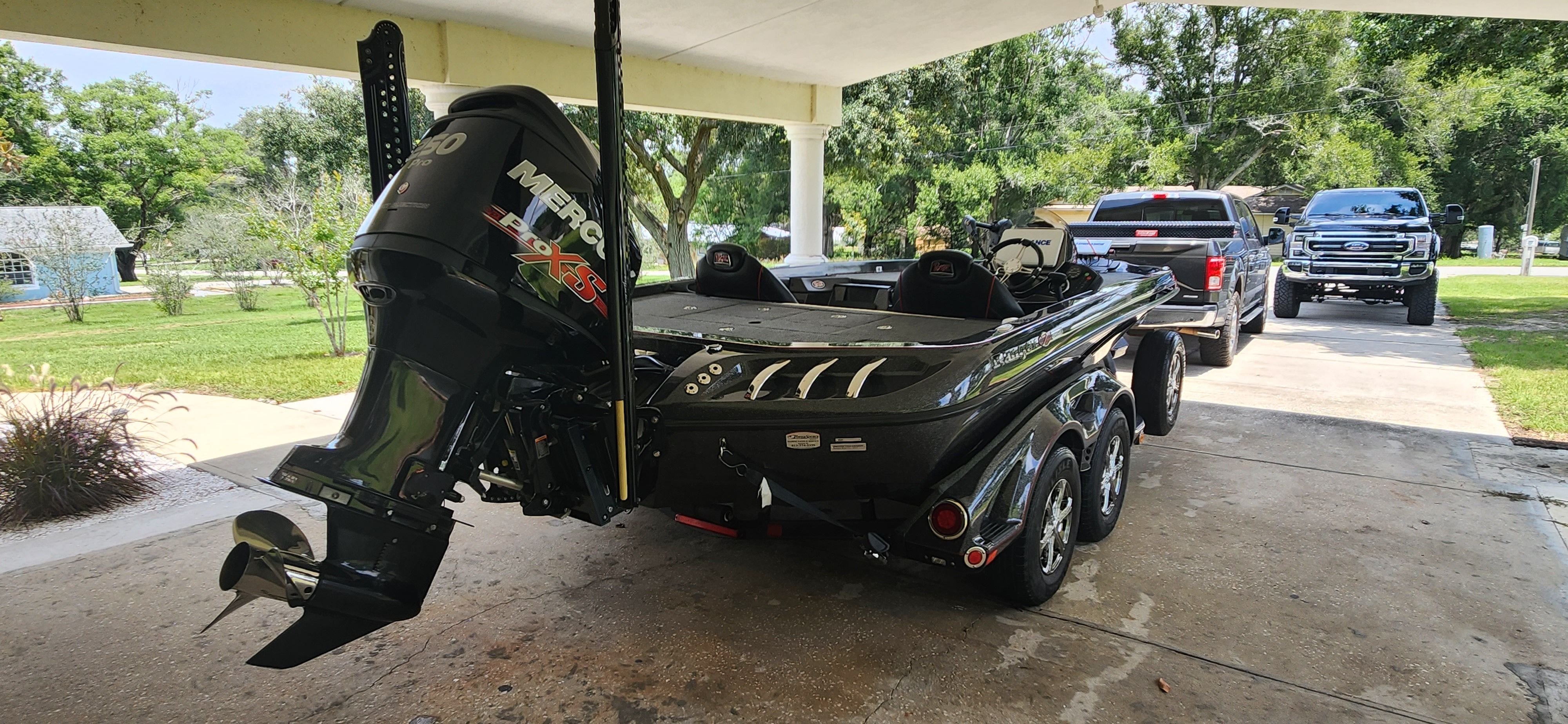 A 2017 Ranger Z520 Comanche on a trailer under a carport. A black outboard motor is visible.