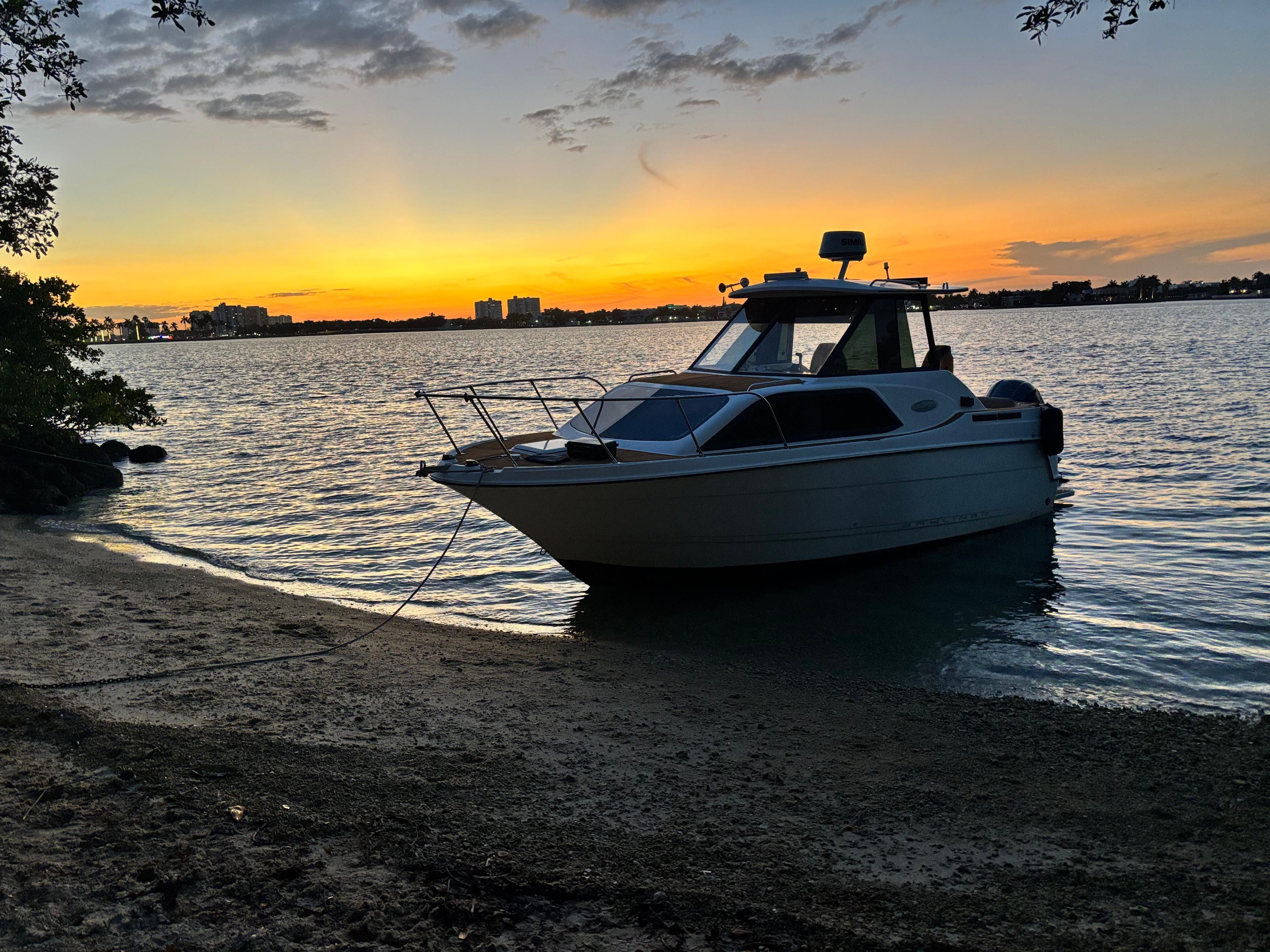 2001 Bayliner 2452 Ciera Classic by the shore at sunset.
