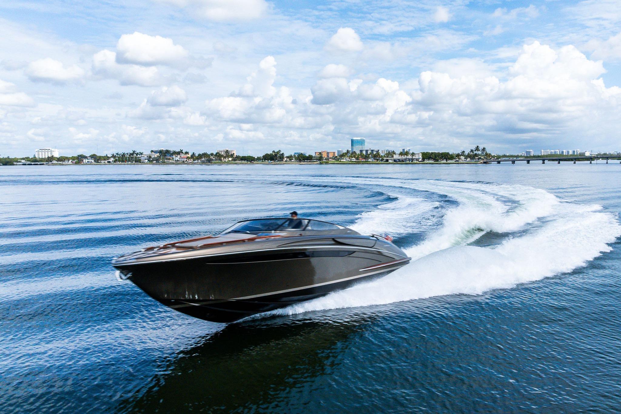 2014 Riva Rivarama luxury yacht cruising on open water under a cloudy sky.