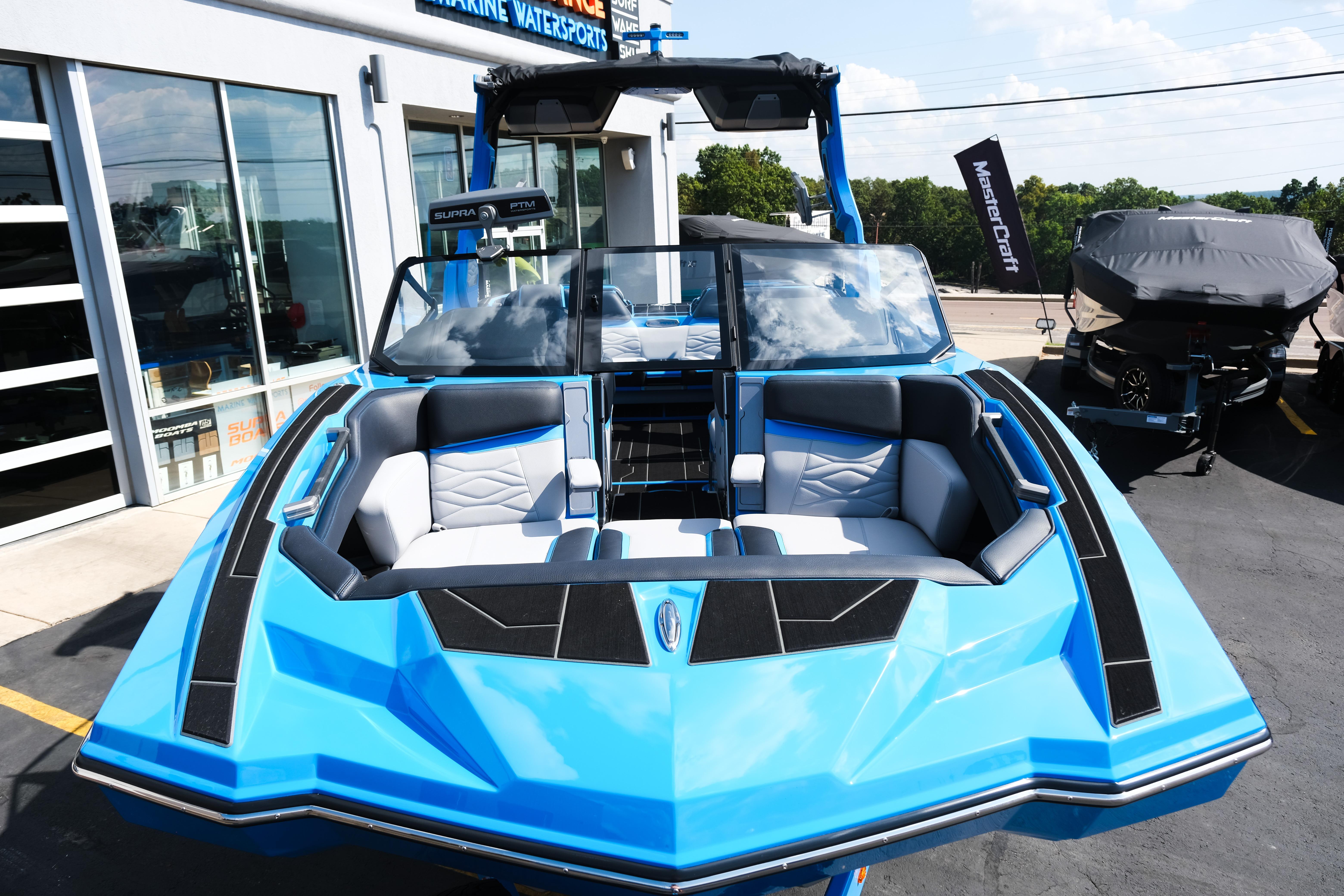 2026 Supra SA450 boat in vibrant blue, displayed at a marine dealership.