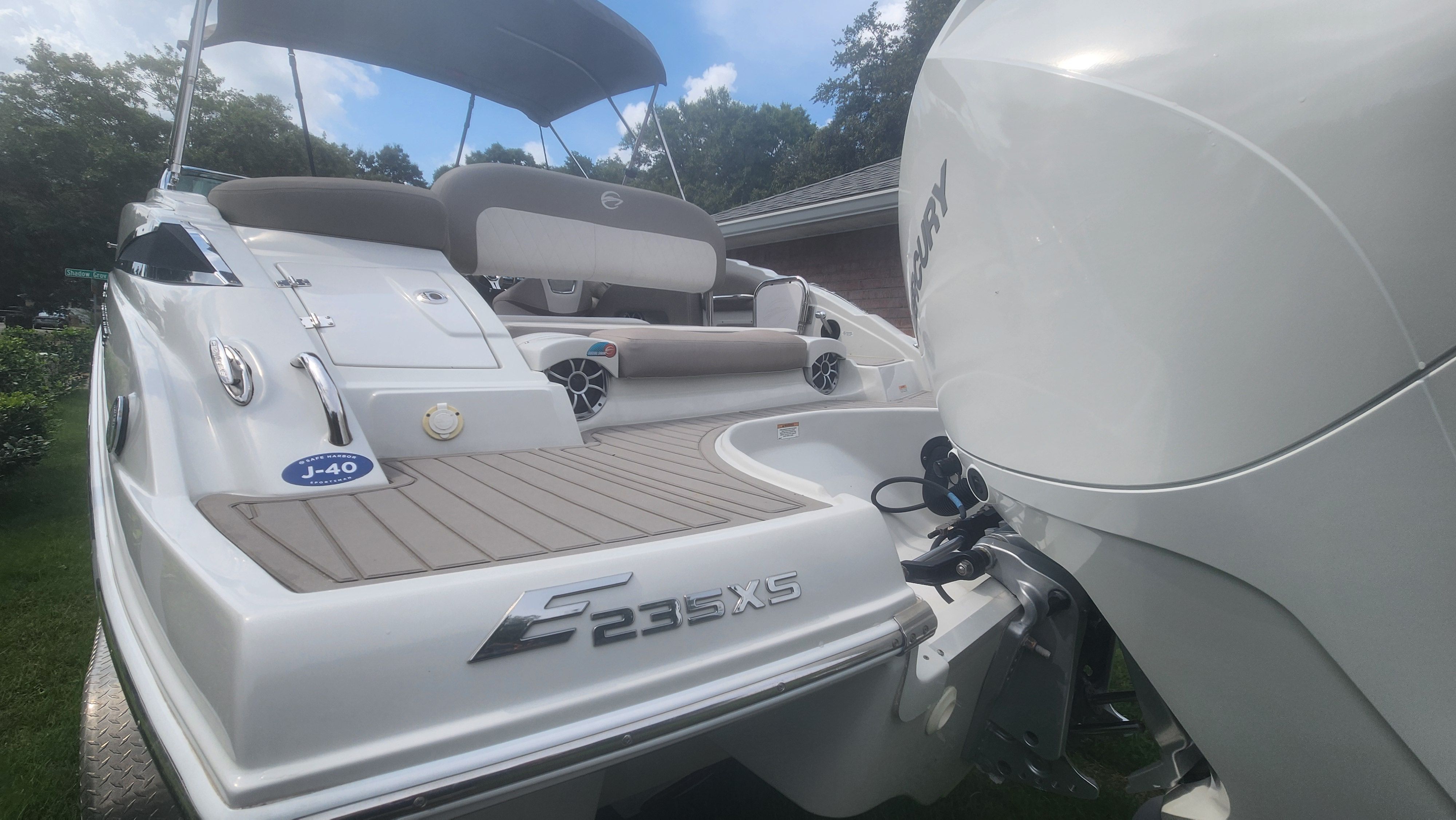 The image shows a 2019 Crownline Eclipse E235 XS boat with an outboard motor. It features sleek design and spacious seating.