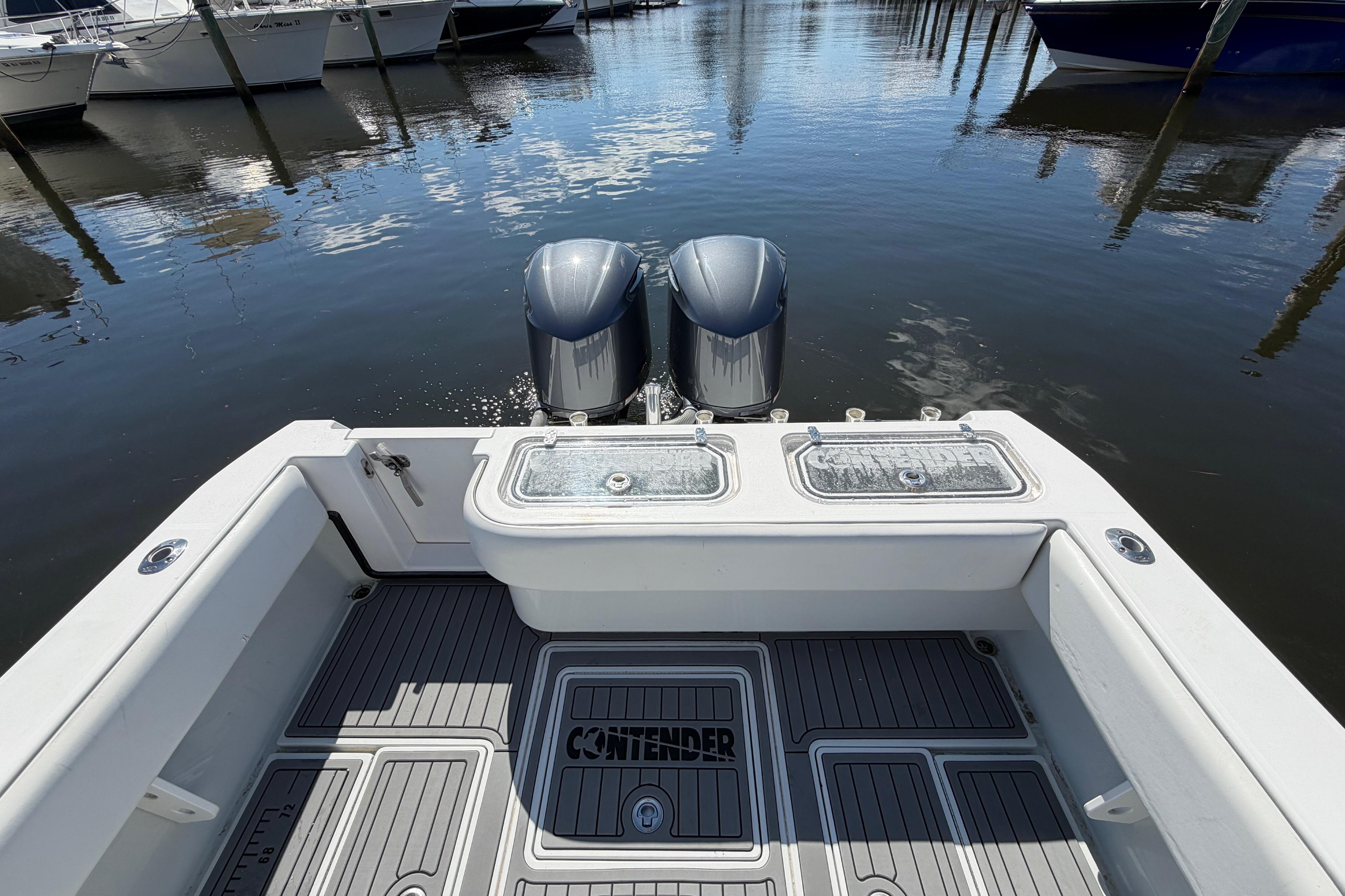 2015 Contender 32 ST boat with dual engines docked at marina.