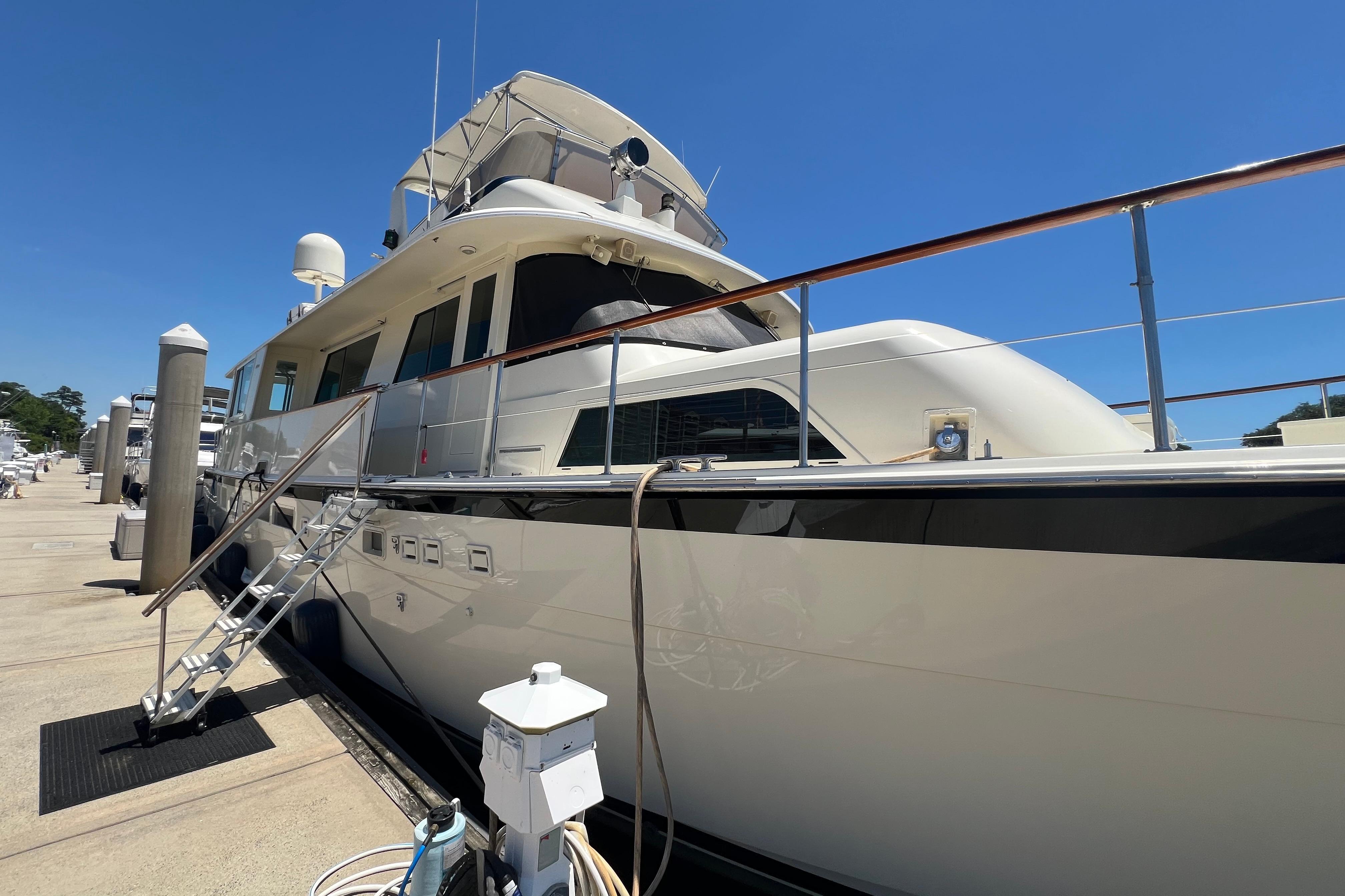 1987 Hatteras 70 Cockpit Motor Yacht docked under clear blue sky.
