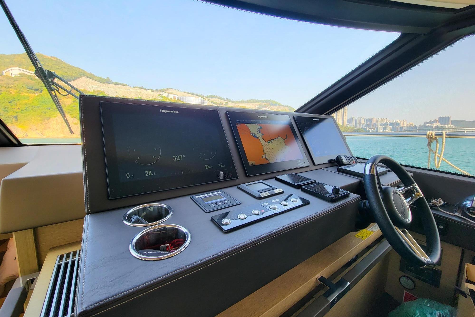 Cockpit of 2019 Prestige 630 yacht with navigation screens and steering wheel.