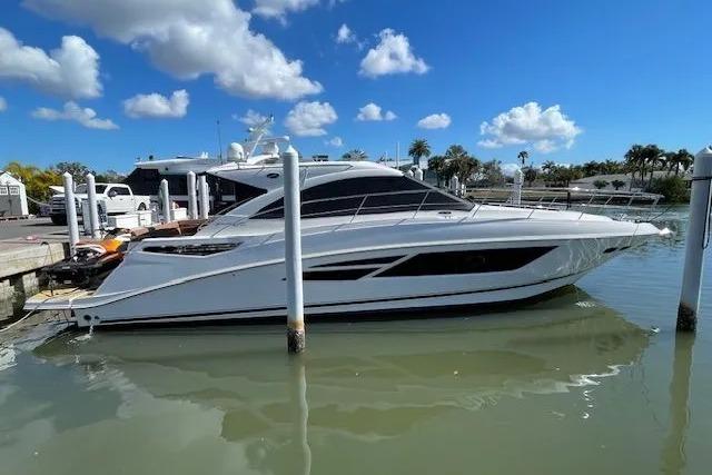 2016 Sea Ray Sundancer 510 yacht docked in a marina under a clear blue sky.